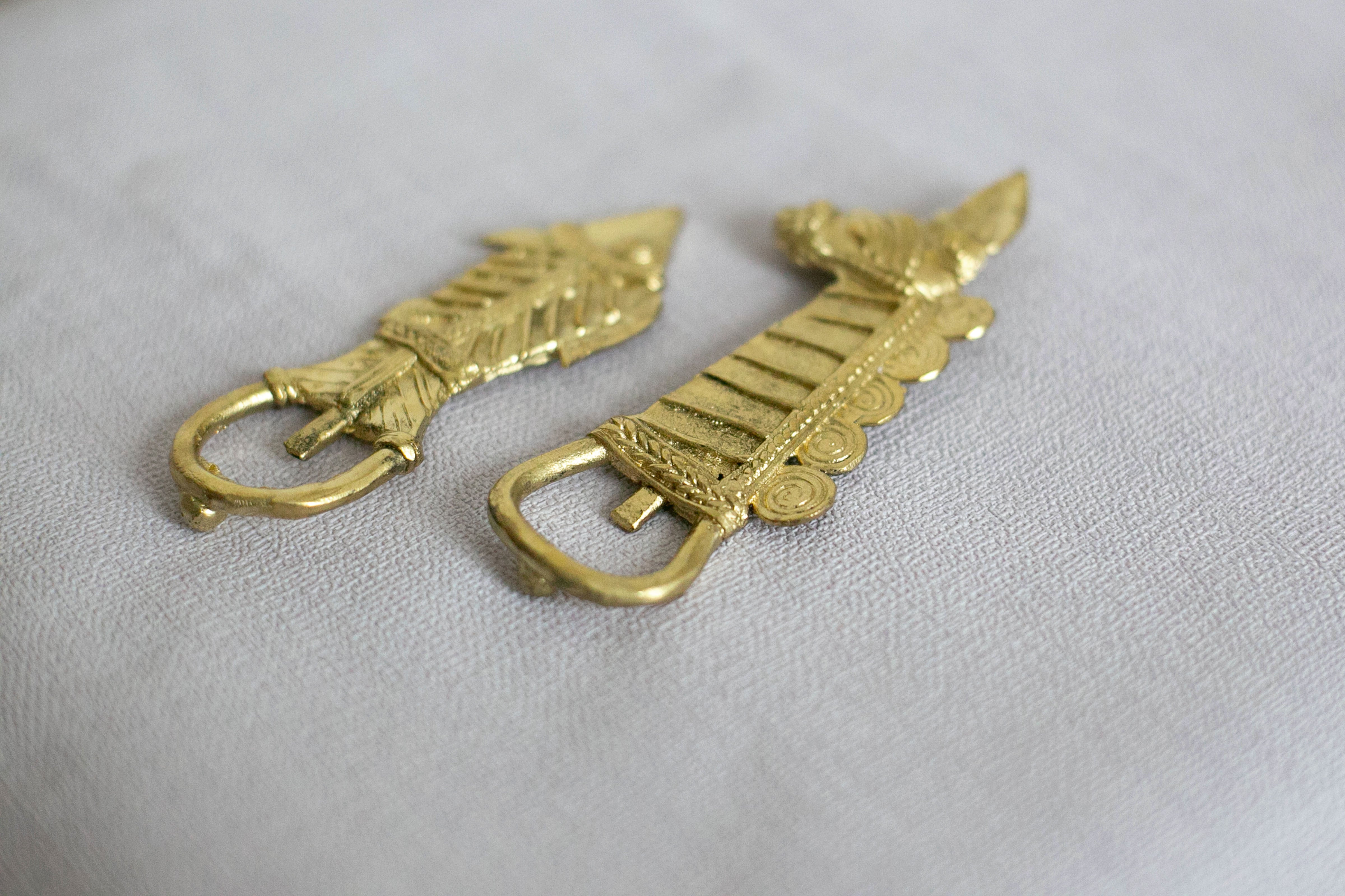 Pair of decorative golden metal hooks with engraved design