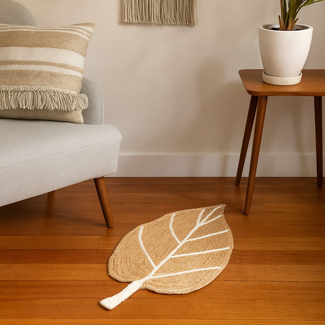 Leaf-shaped rug on a wooden floor with a chair and plant in the background