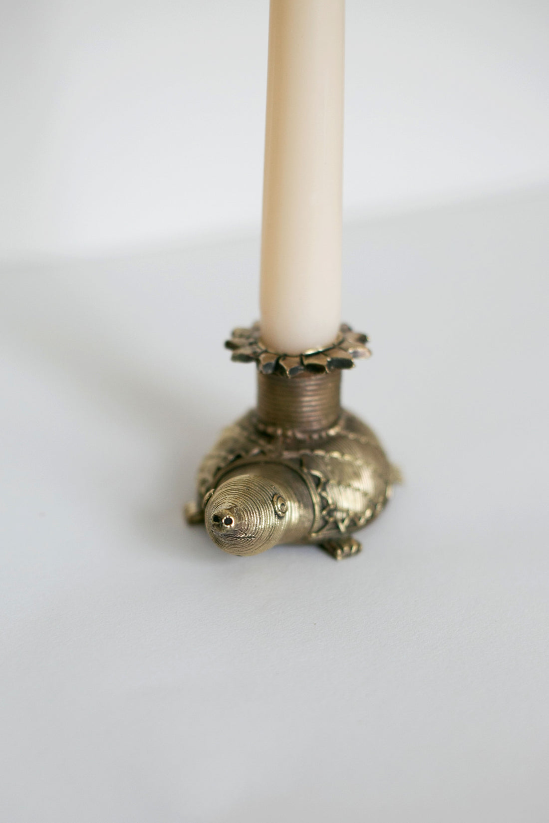 Decorative metal turtle candlestick on neutral background