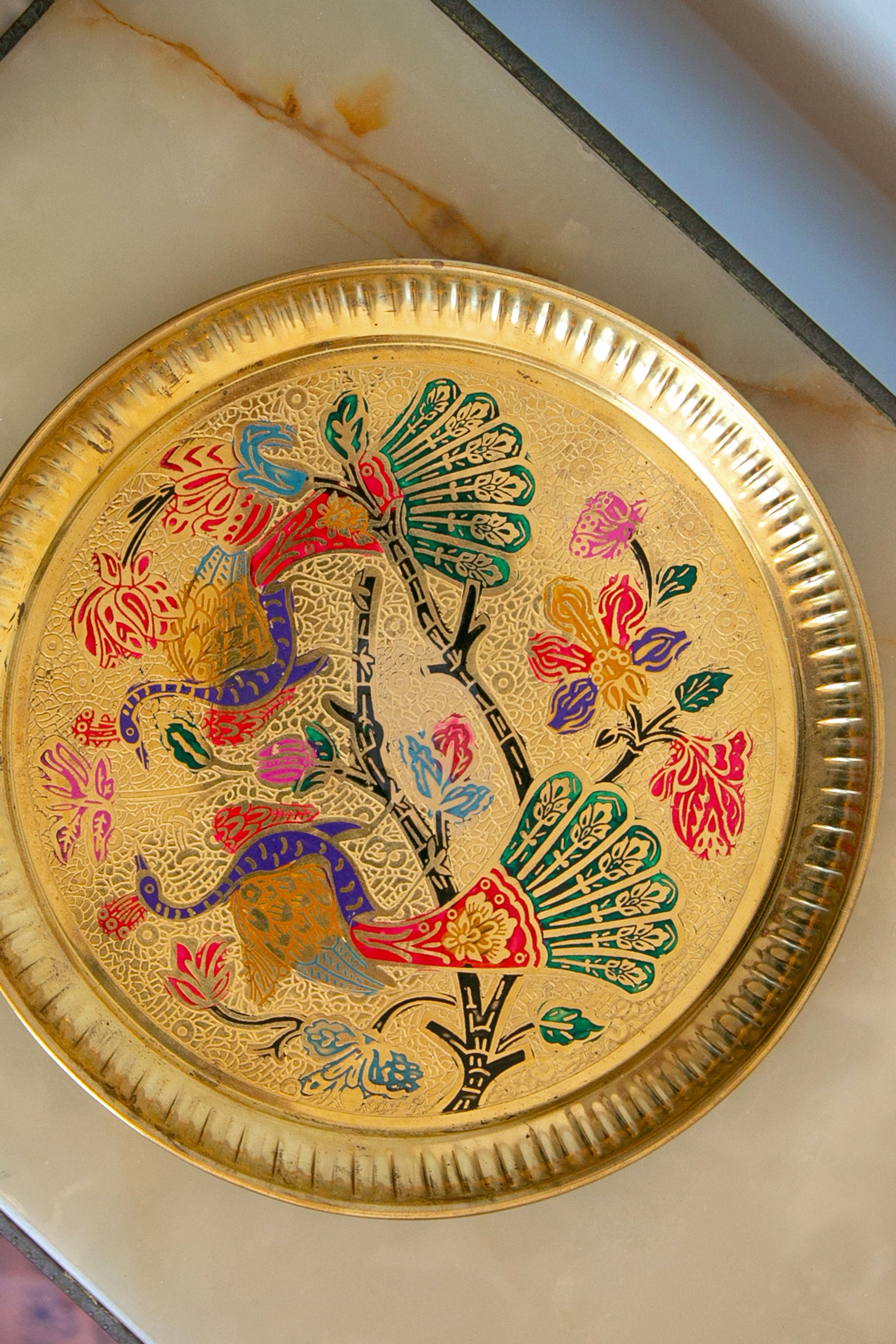 Ornate golden plate with colorful birds and floral patterns.