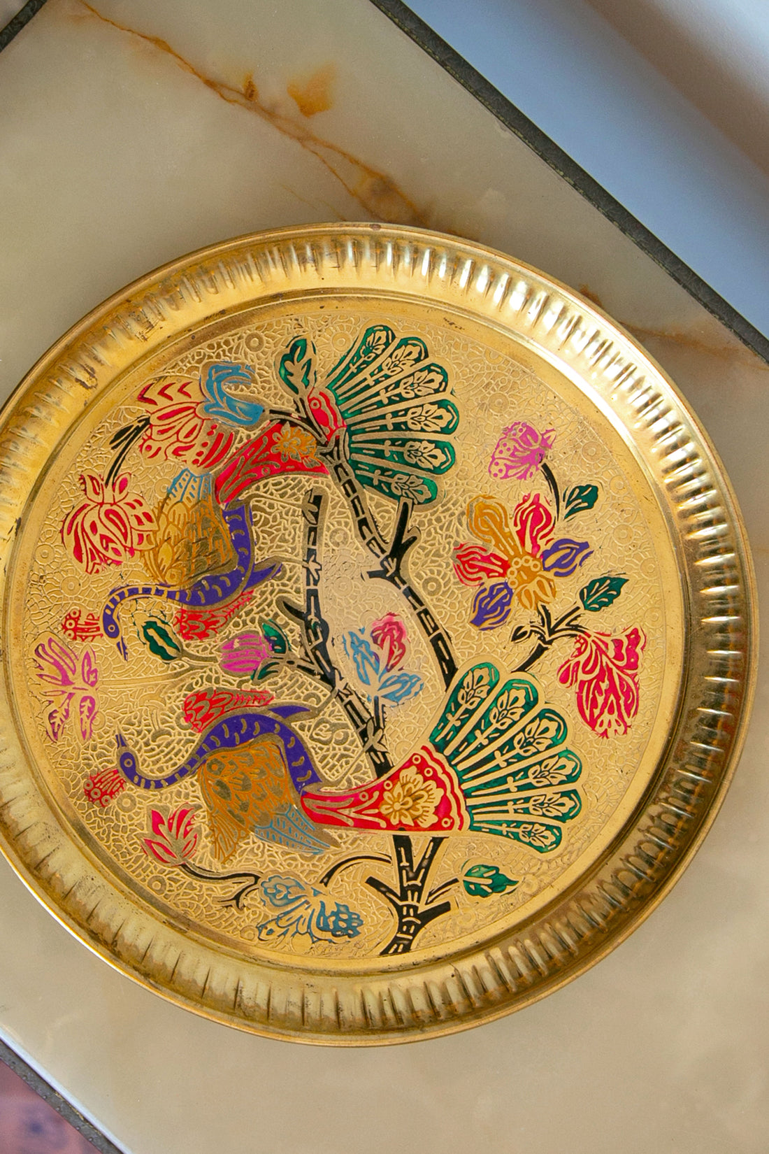 Ornate golden plate with colorful birds and floral patterns.