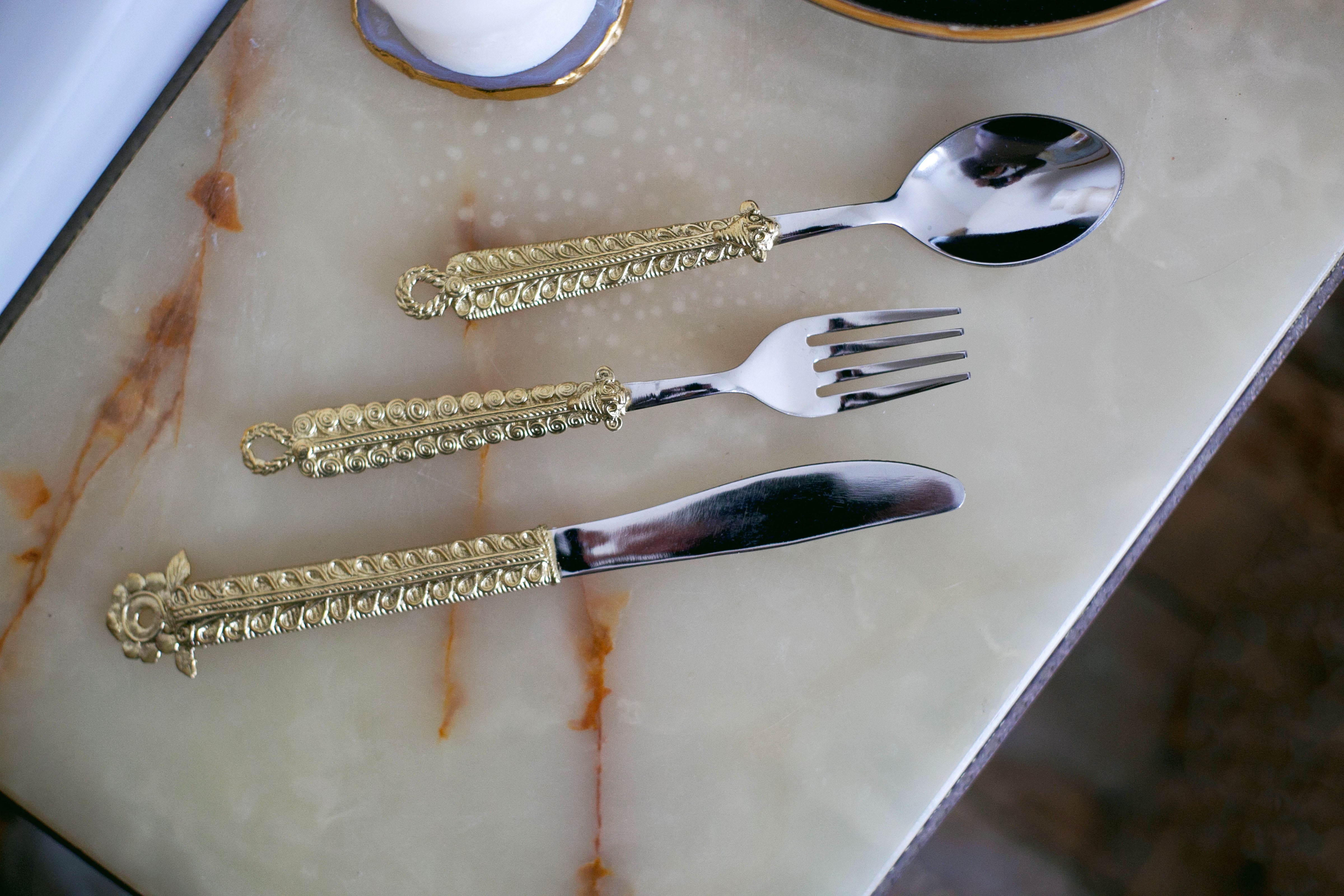 Luxurious gold-handled cutlery set on marble surface