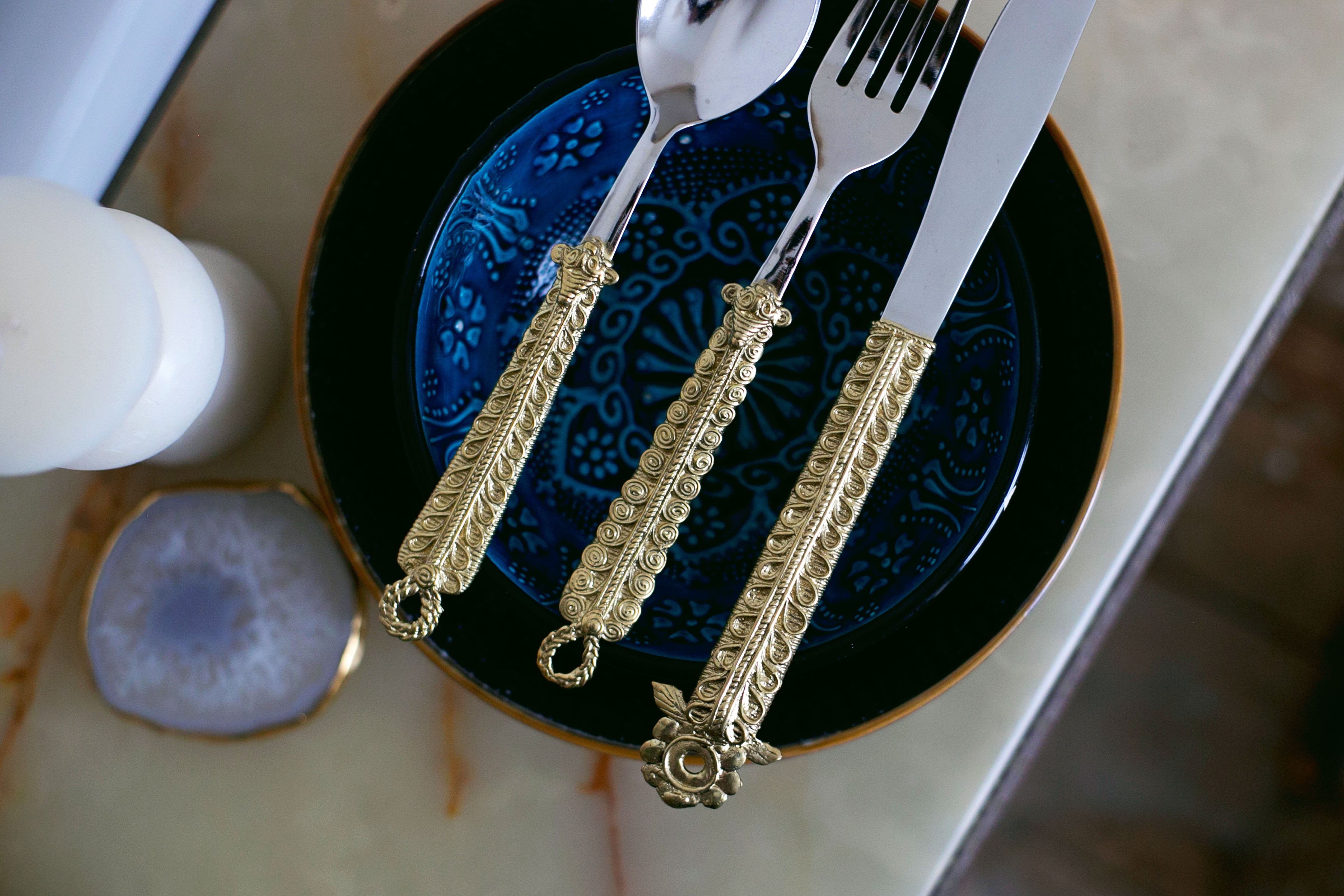 Luxury dining setup with golden utensils and blue crockery