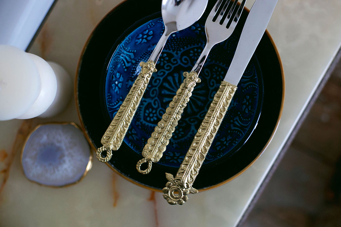 Luxury dining setup with golden utensils and blue crockery