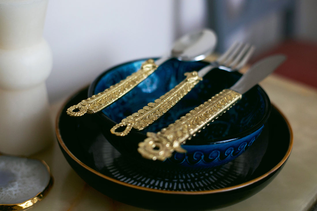Decorative gold cutlery set on blue bowl and plate