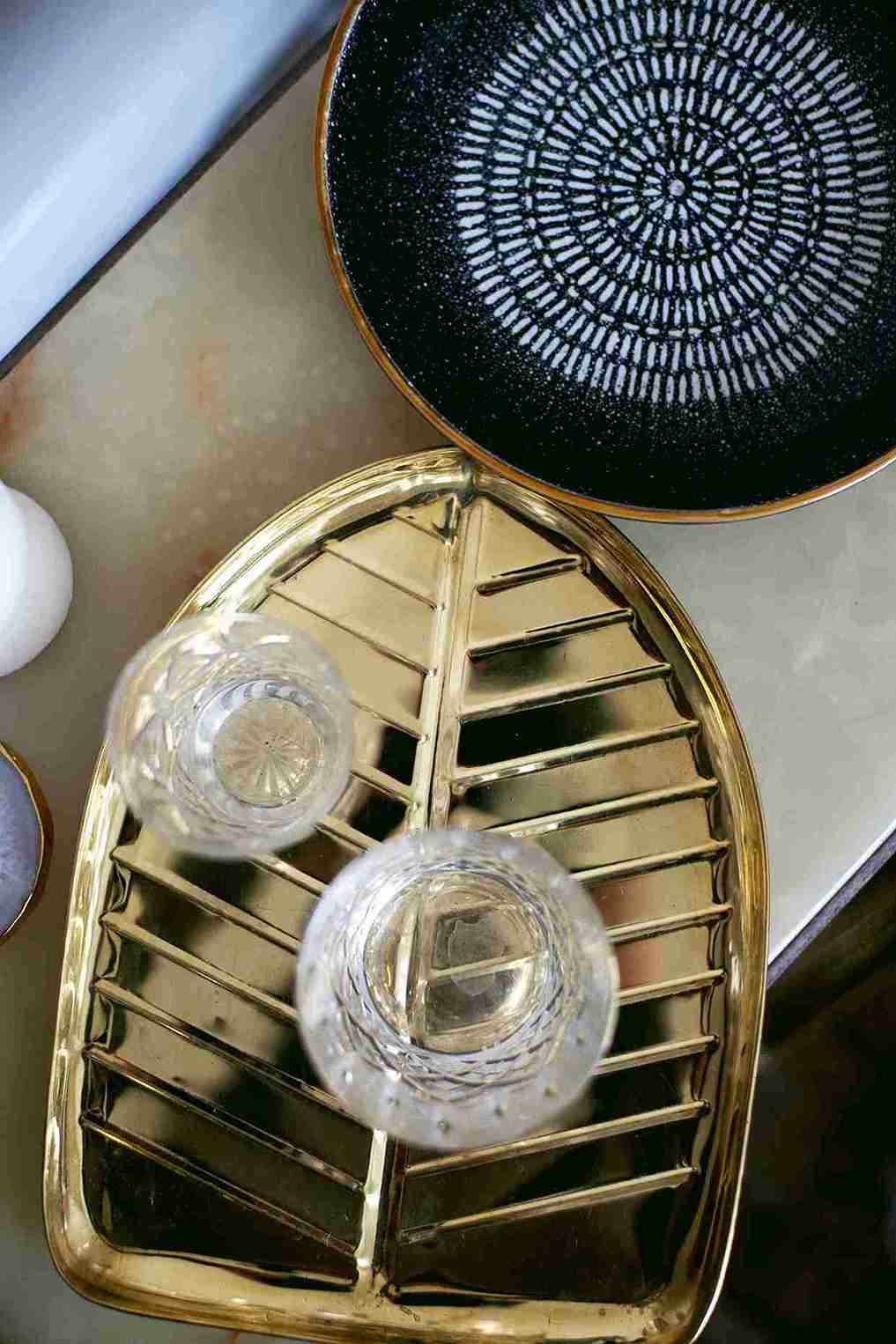 Gold decorative tray with glass coasters on a white surface