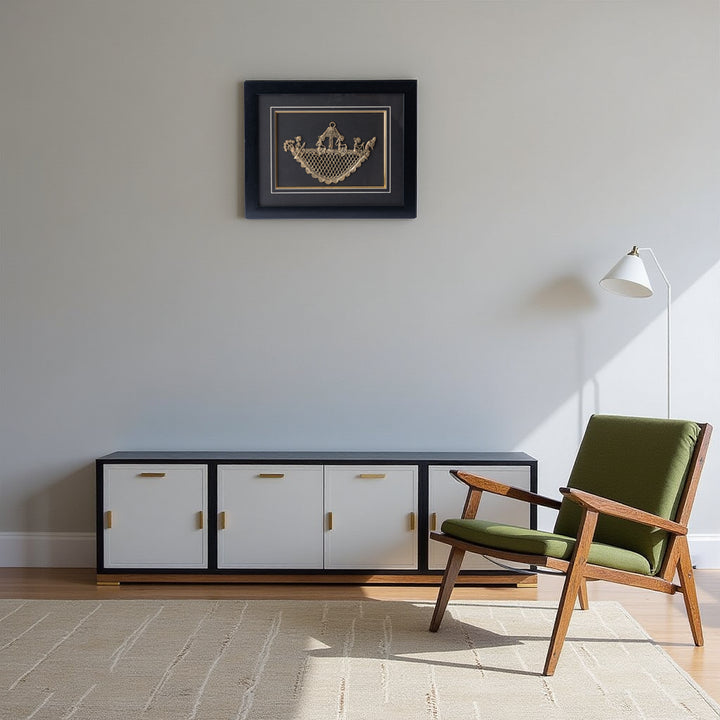 Modern living room with a green chair, black cabinet, and framed artwork on the wall.