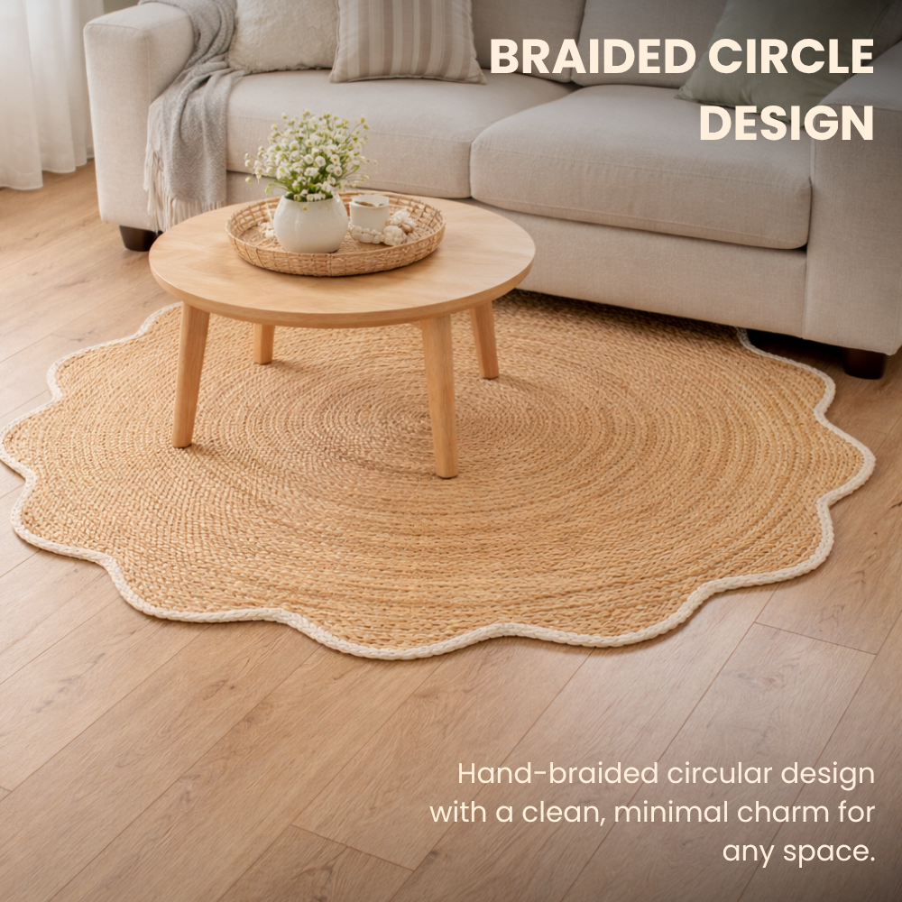 Round braided jute rug on a wooden floor with a sofa and coffee table in the background.