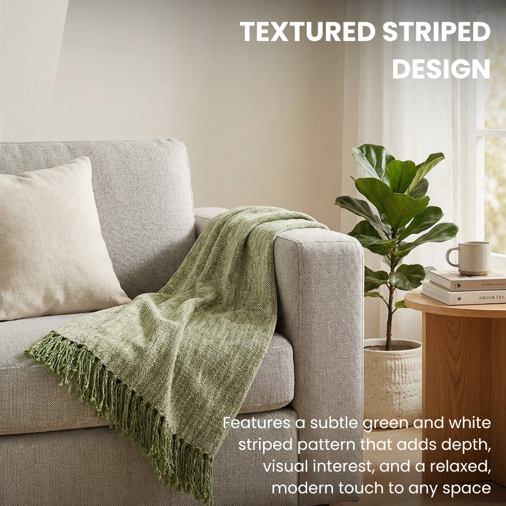 Textured striped green blanket on a gray sofa with a plant and books in the background.