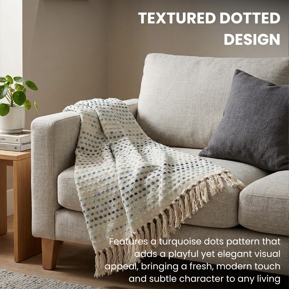 Textured dotted design blanket draped over a gray sofa with a neutral background