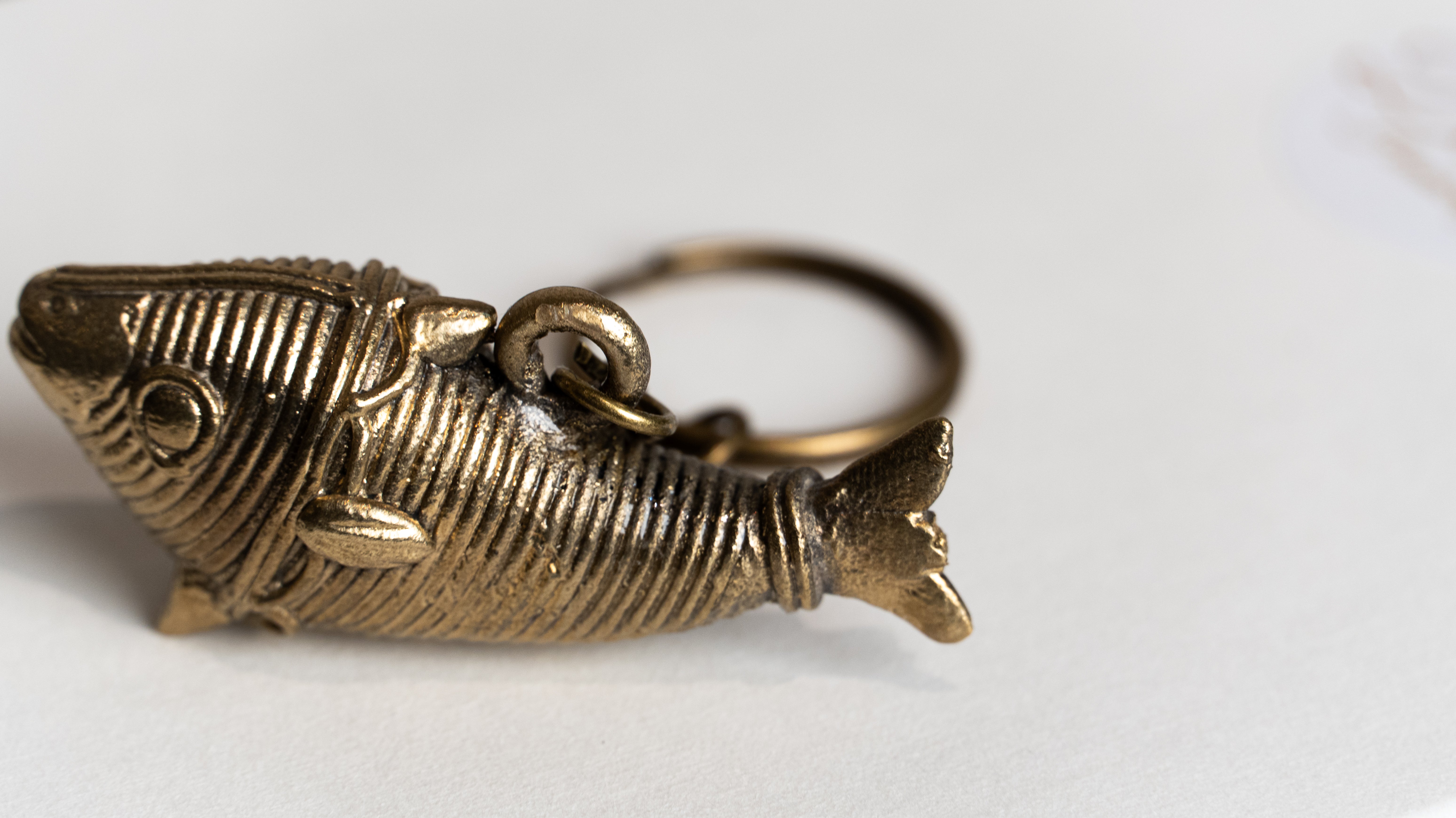 Golden metallic fish-shaped keychain with detailed scales, fins, and eye attached to a circular ring