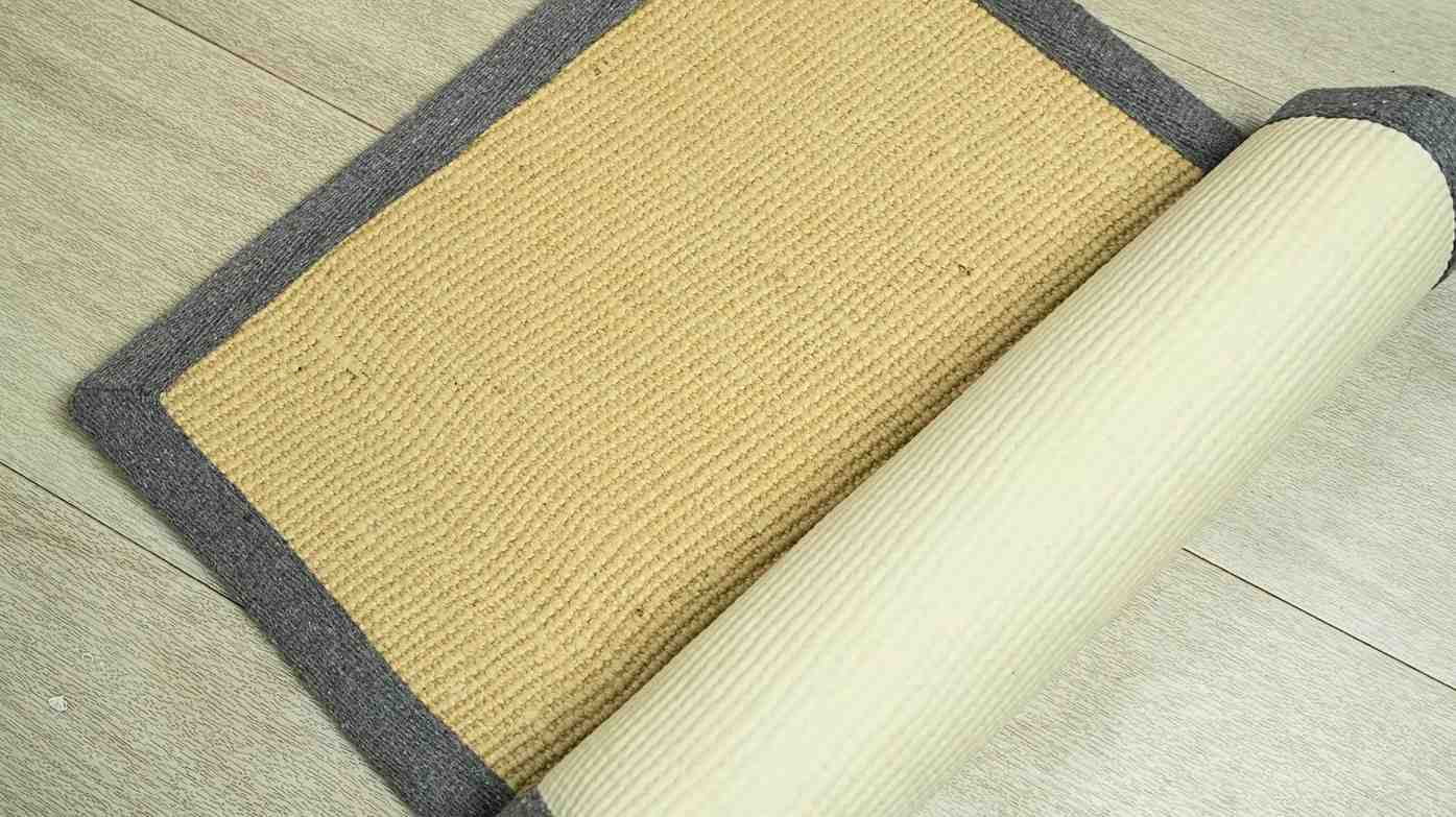Beige doormat with a gray border on a wooden floor