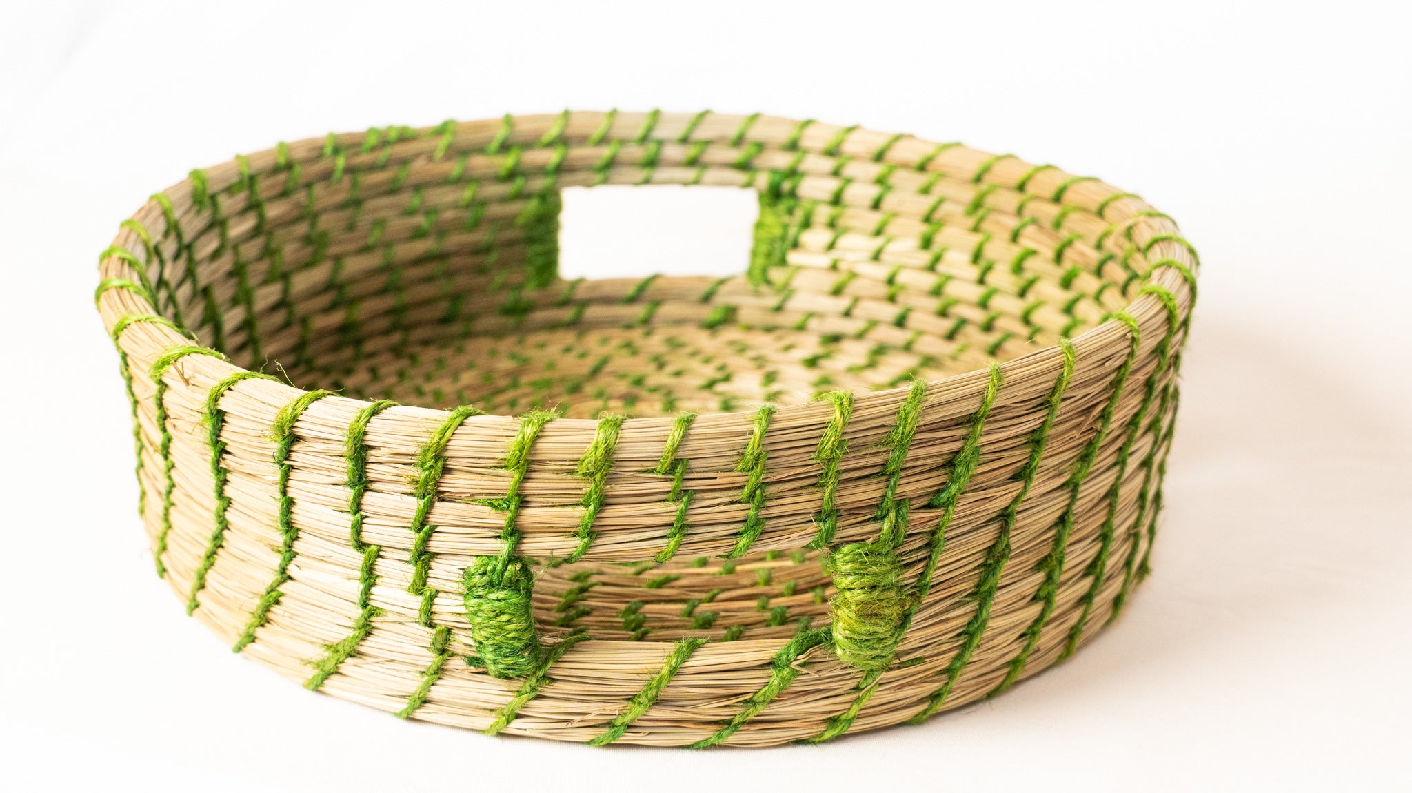 Woven basket with green accents on a white background