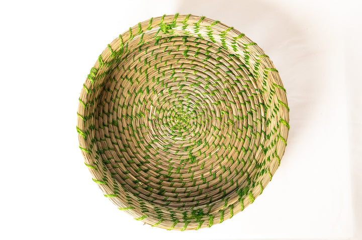 Woven basket with green accents on a white background