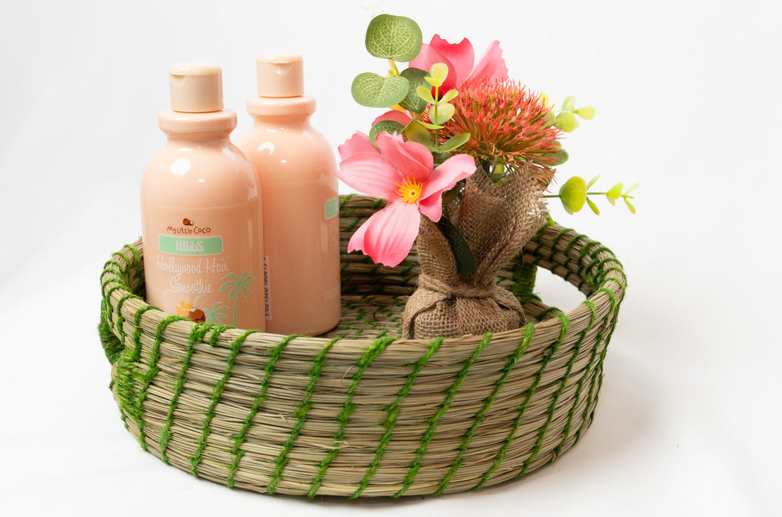 Two bottles of lotion and a small bouquet of flowers in a woven basket on a white background