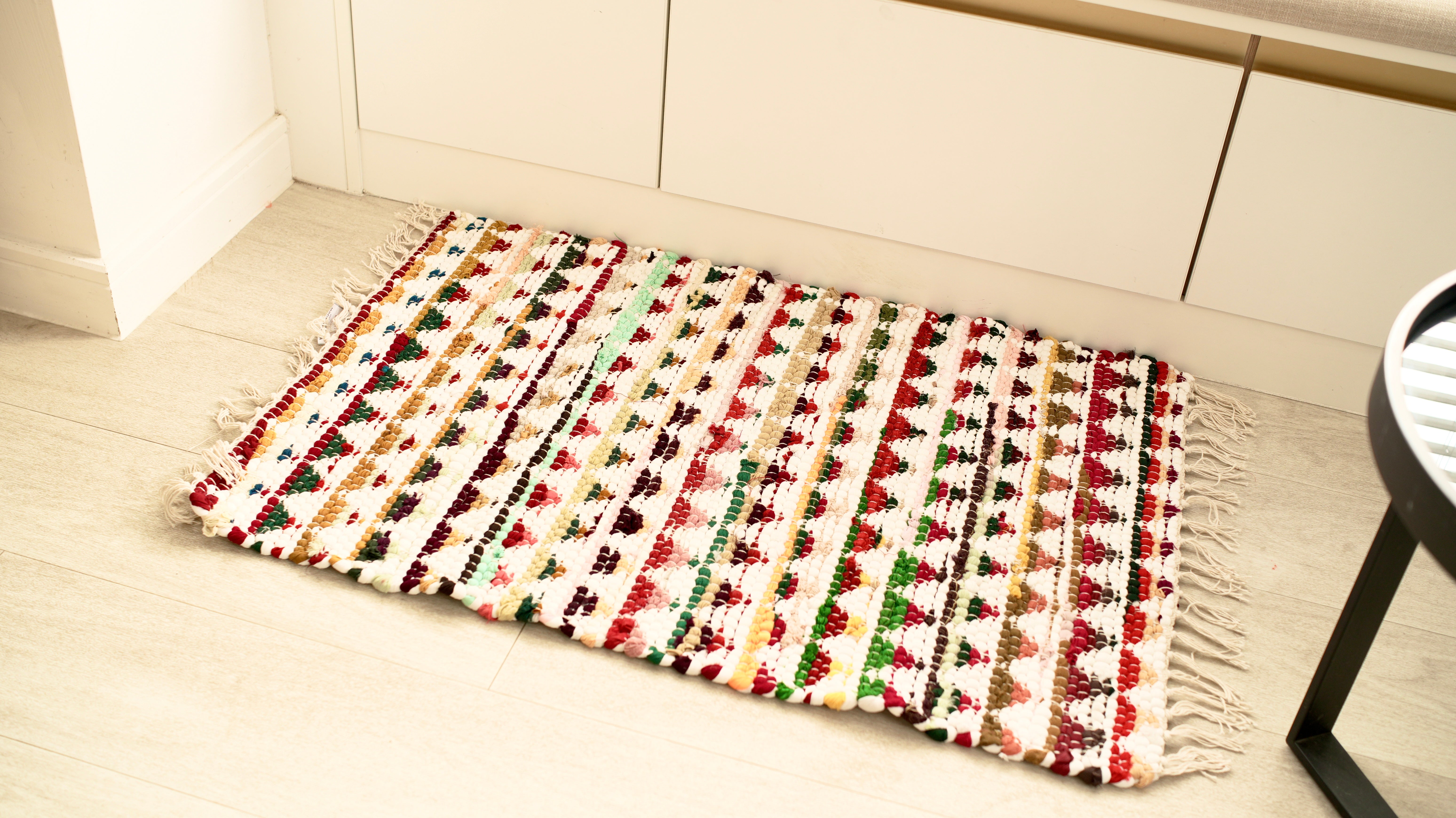 Multicolored woven mat on a wooden floor