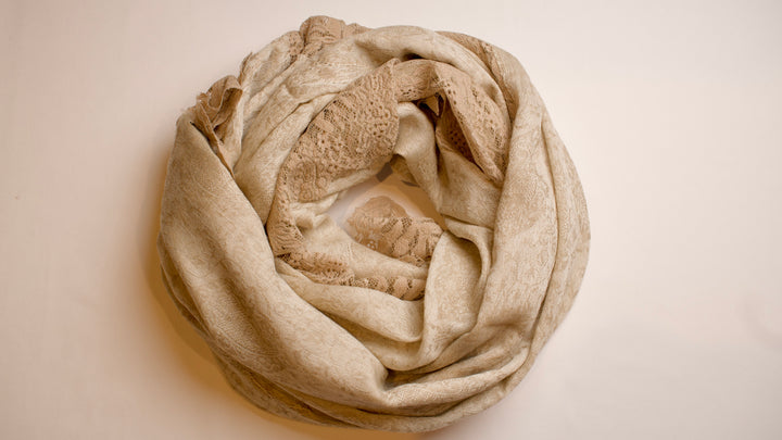 Beige scarf folded into a circle on a beige background