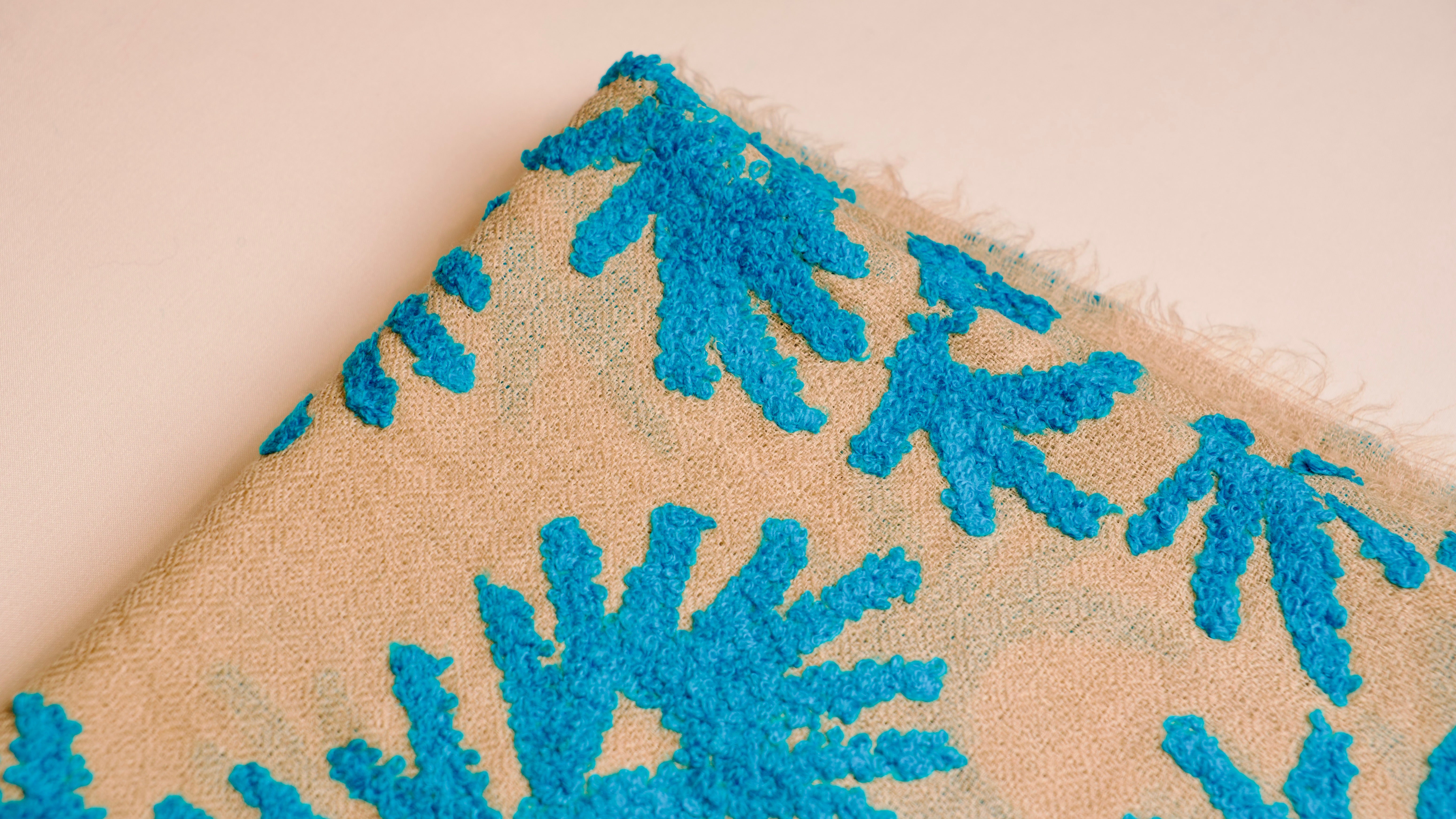 Close-up of a textured surface with blue floral patterns on a beige background