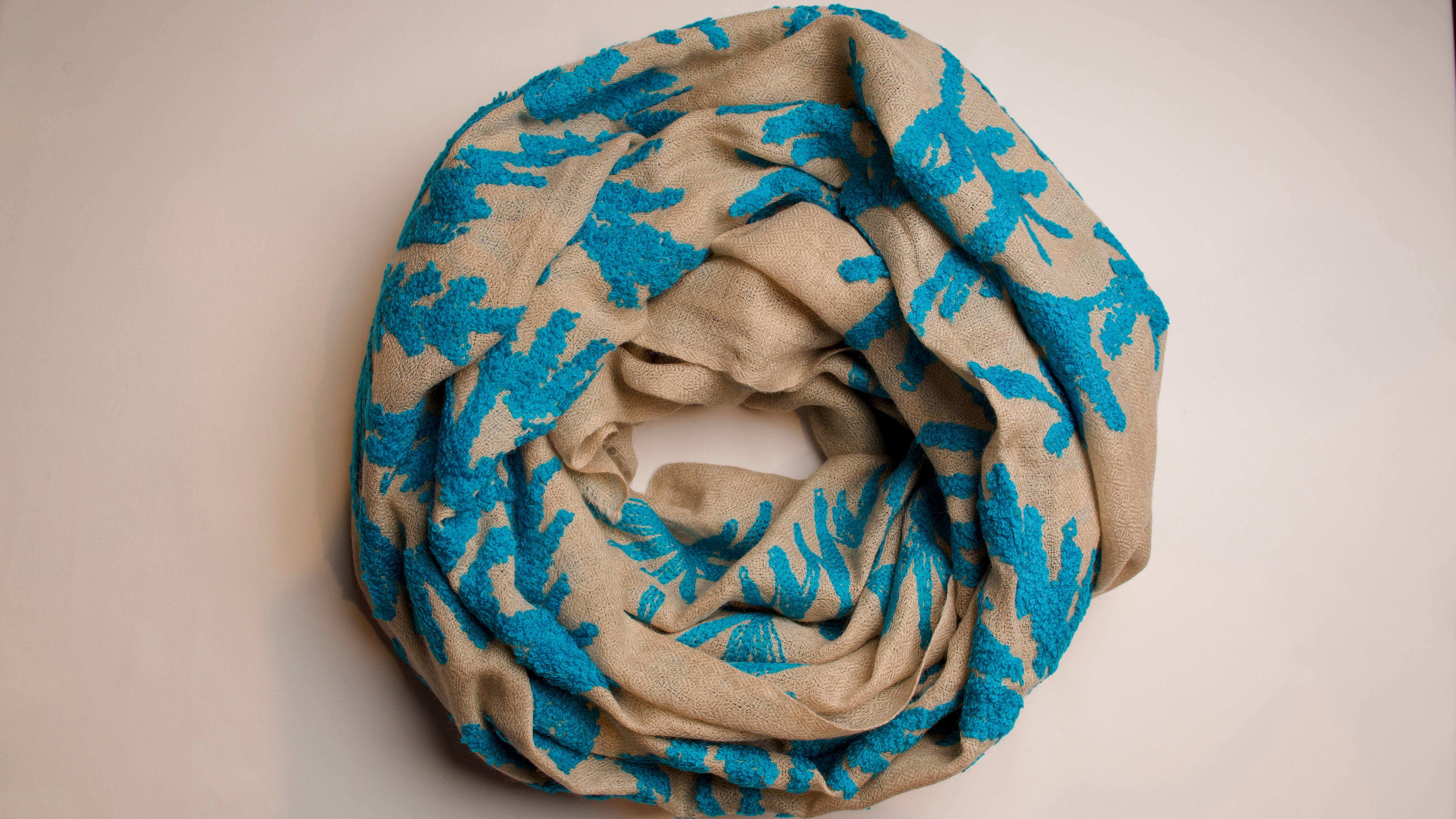 Beige scarf with blue floral patterns on a beige background