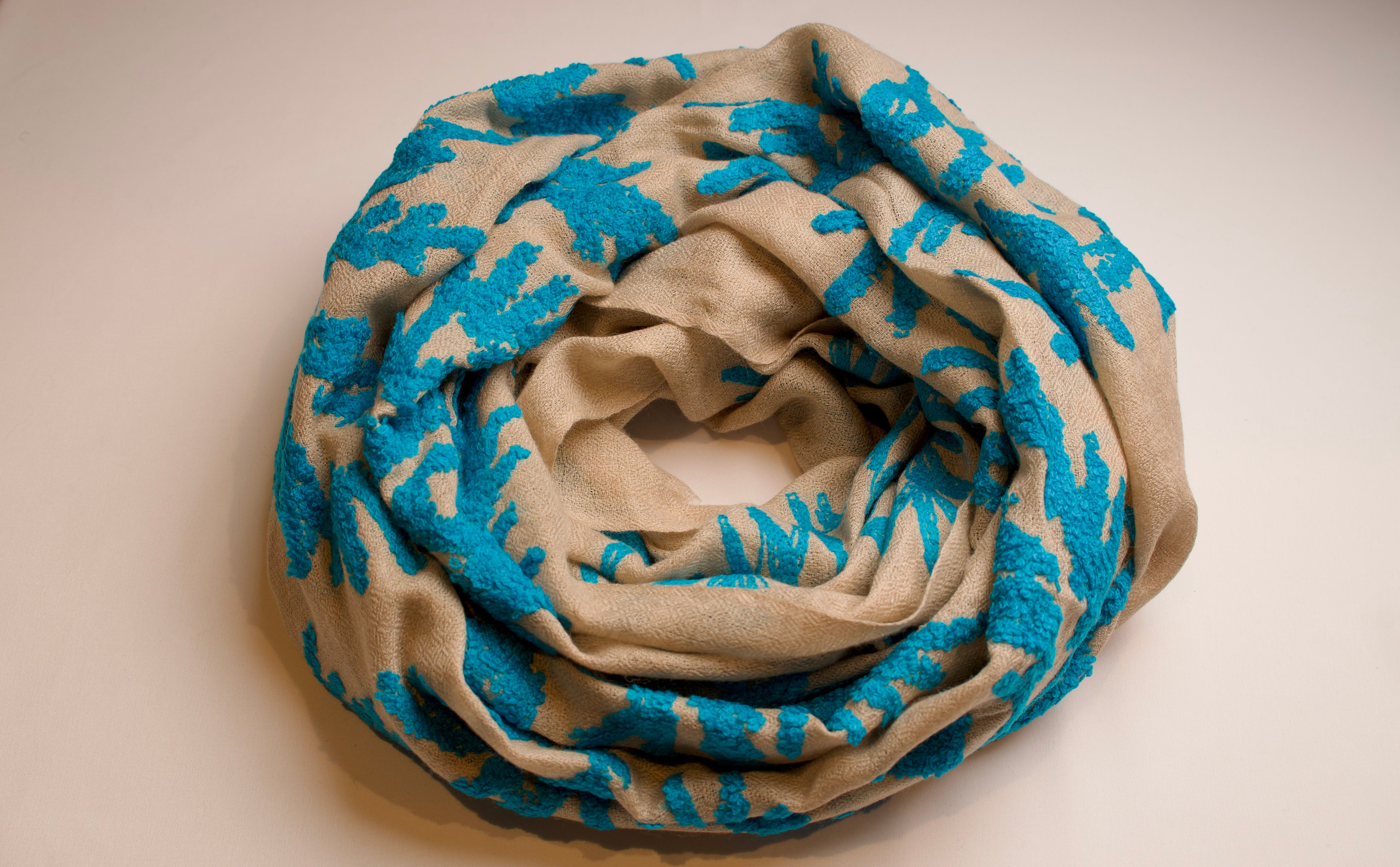 Folded scarf with blue and beige pattern on a beige background
