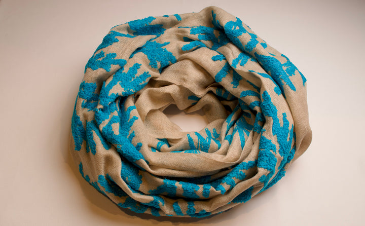 Folded scarf with blue and beige pattern on a beige background
