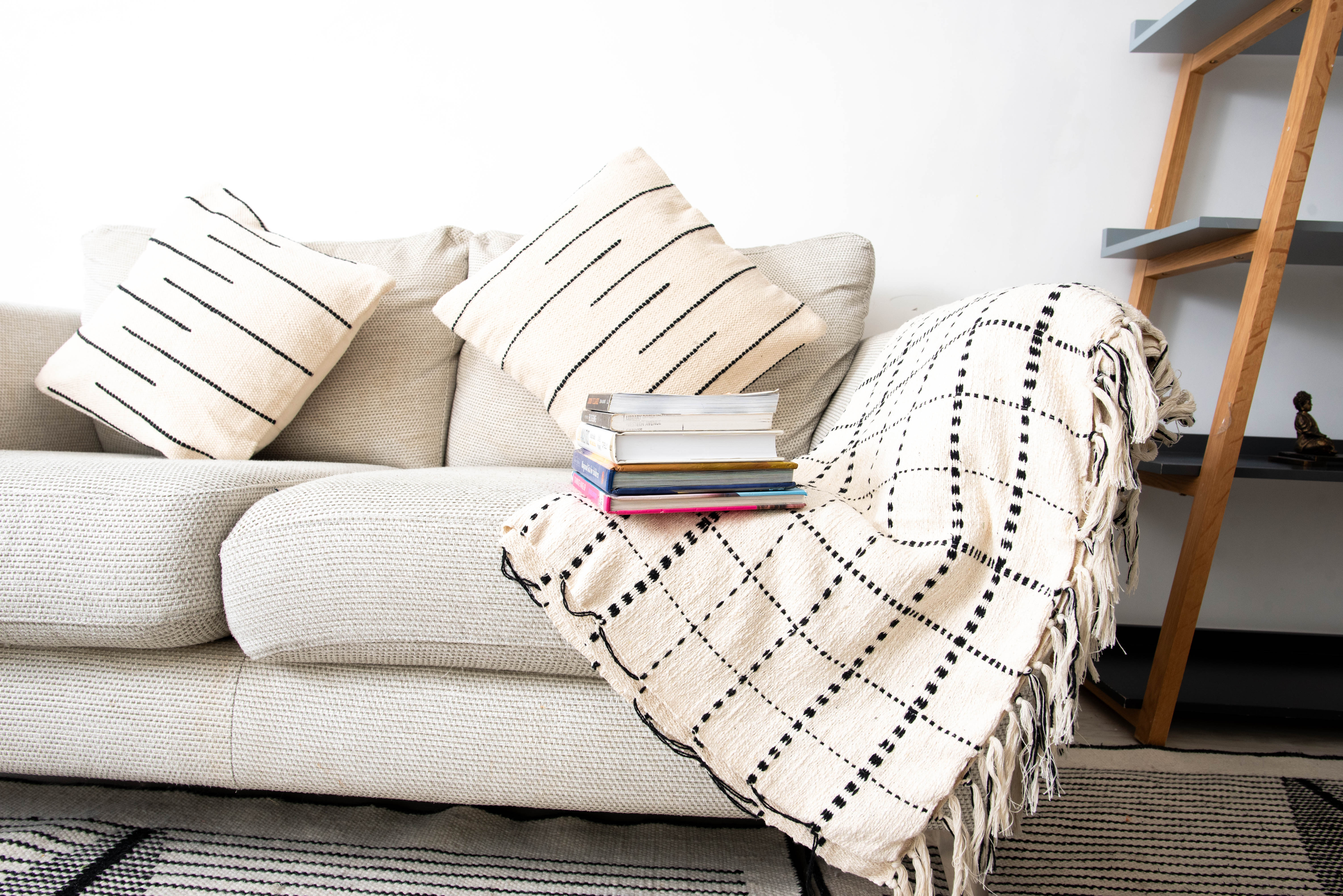 Neutral-toned sofa with decorative pillows and books