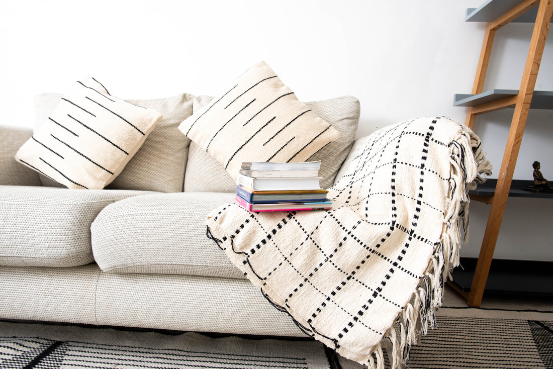 Neutral-toned sofa with decorative pillows and books