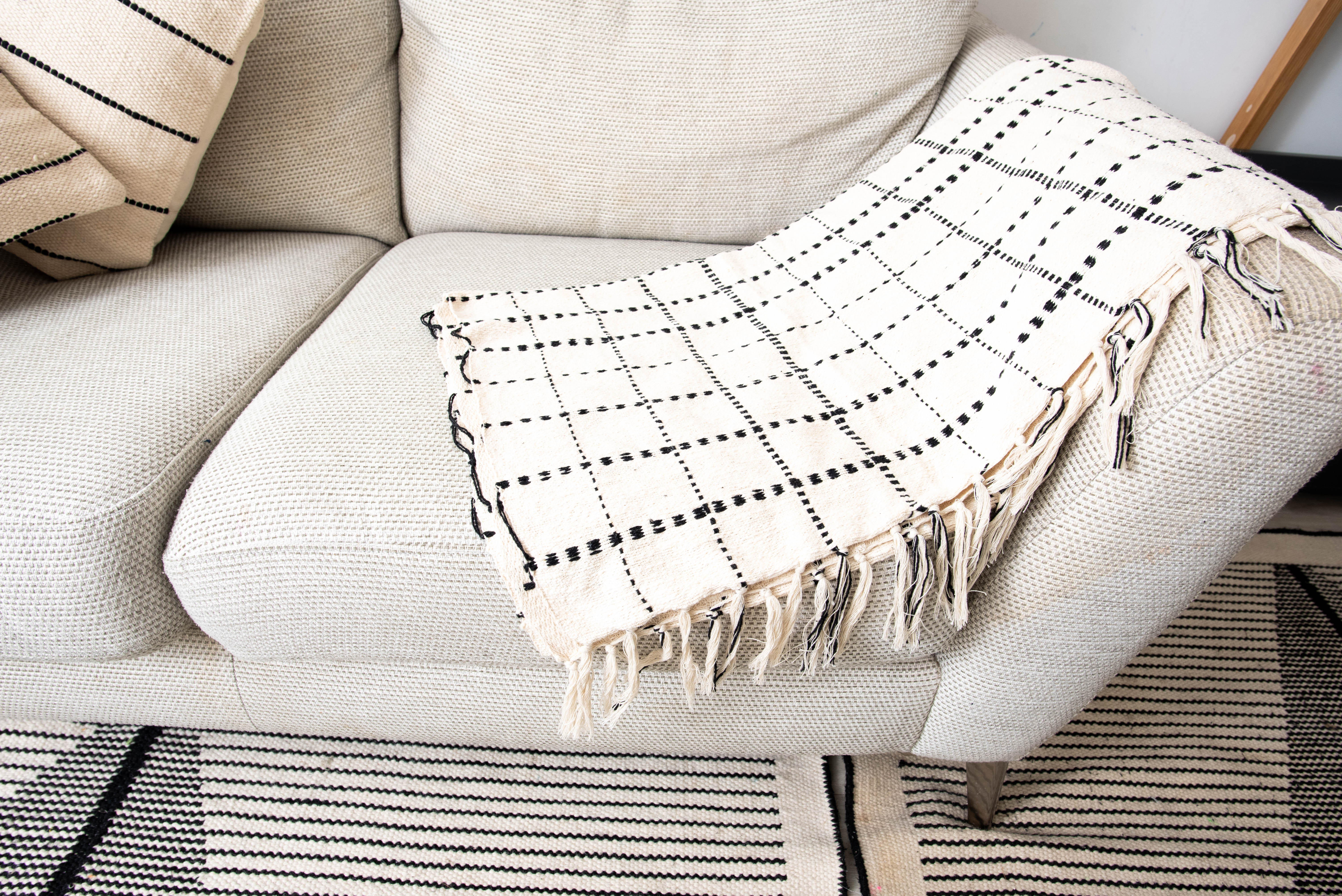 Beige fabric sofa on patterned rug 
