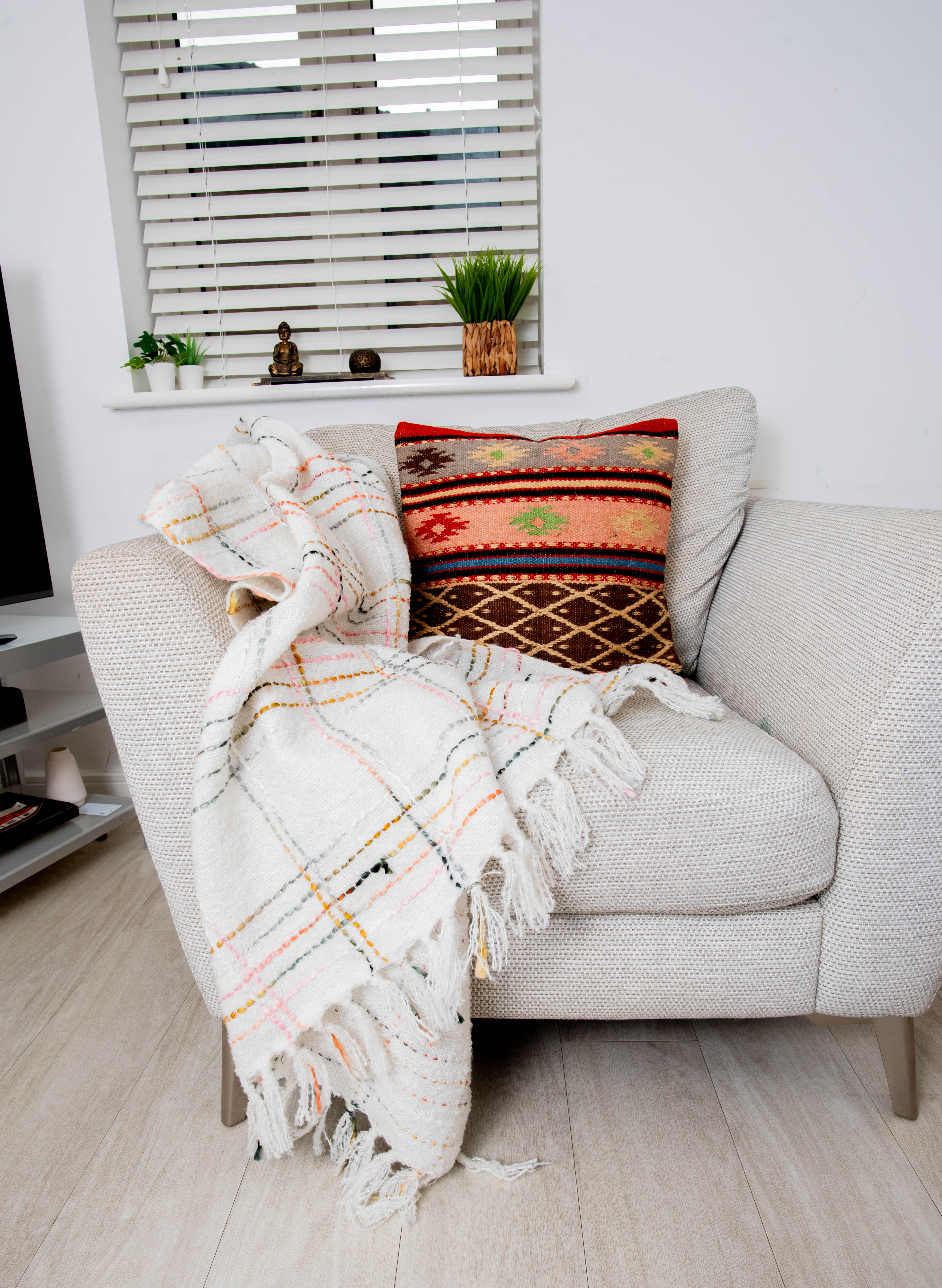 Cozy gray armchair with plaid throw and woven pillow