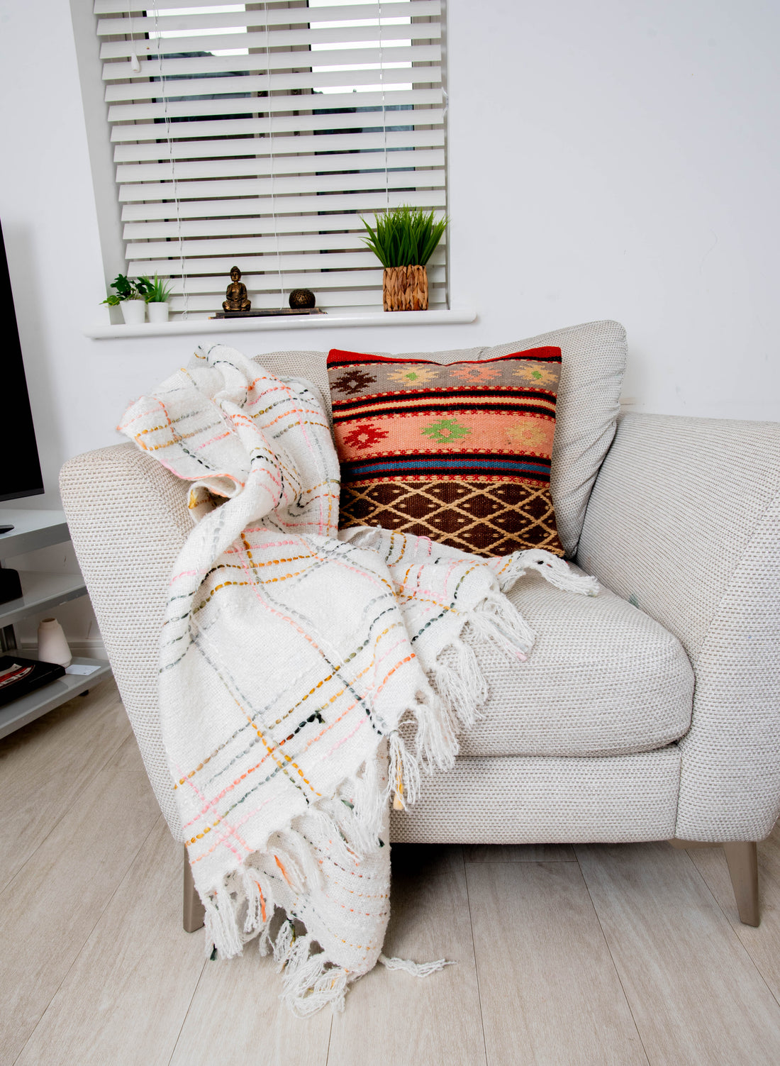 Cozy gray armchair with plaid throw and woven pillow
