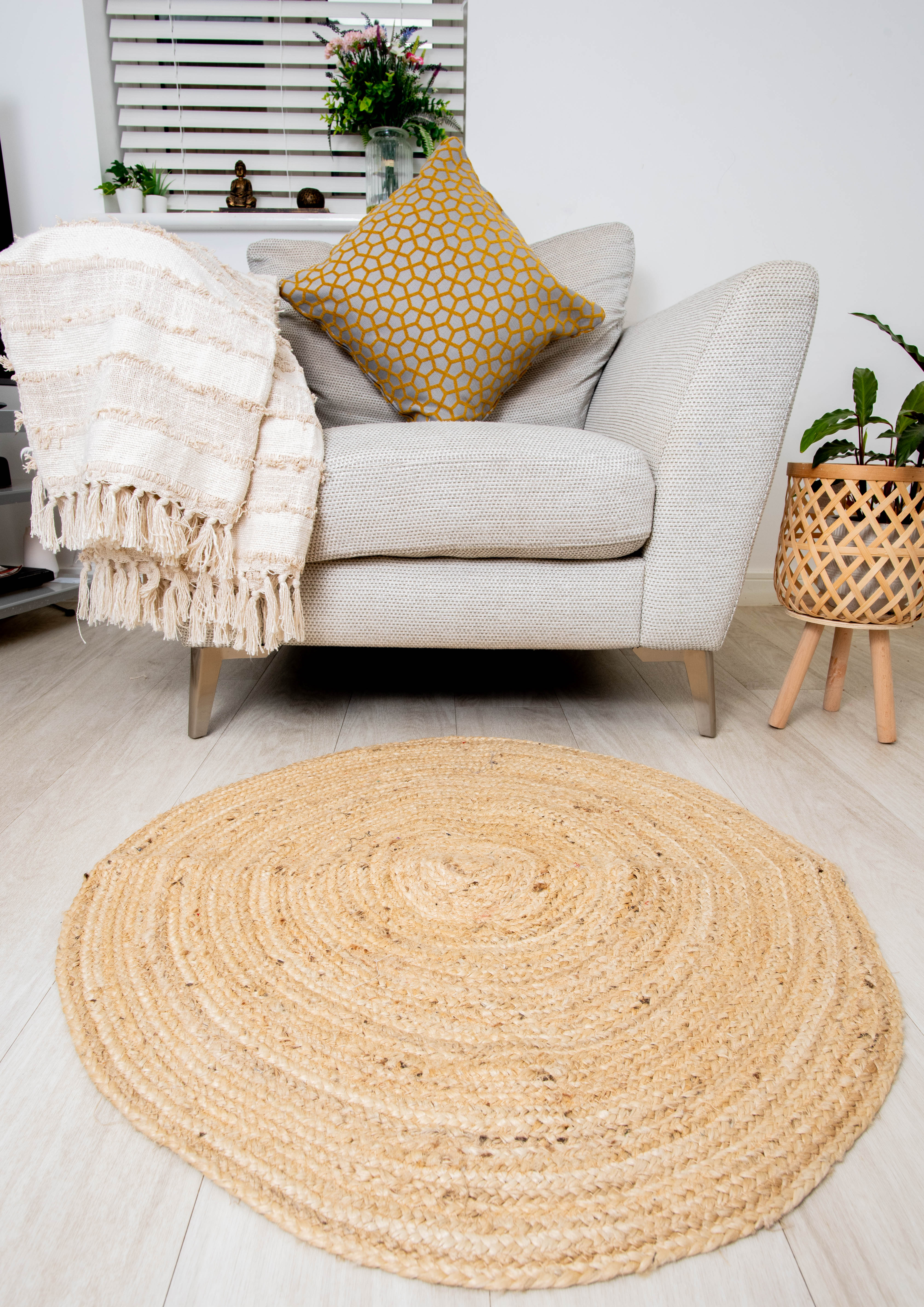 Handmade jute rug beside Modern beige sofa with patterned cushions and throw