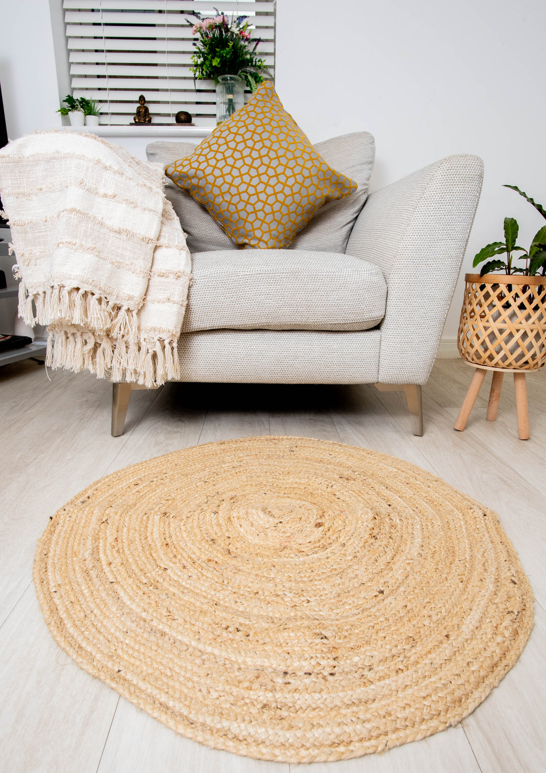 Handmade jute rug beside Modern beige sofa with patterned cushions and throw