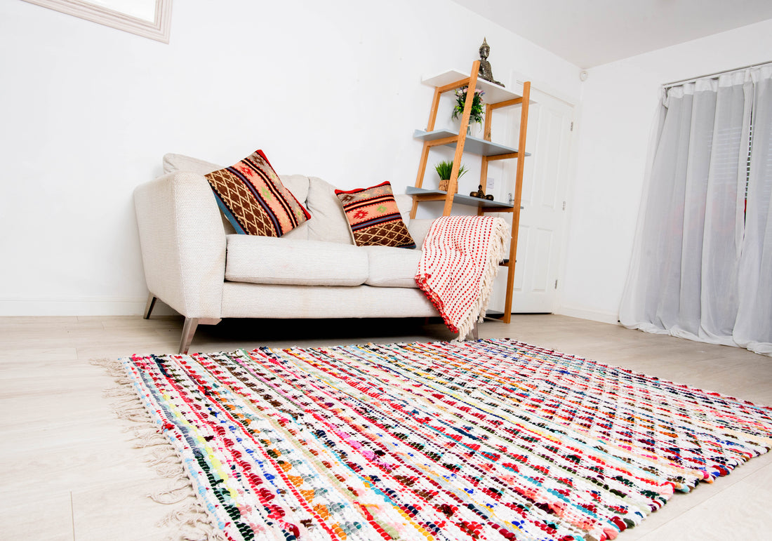 This colorful rug appears to be a Chindi or rag rug, often handwoven from recycled fabric strips. 