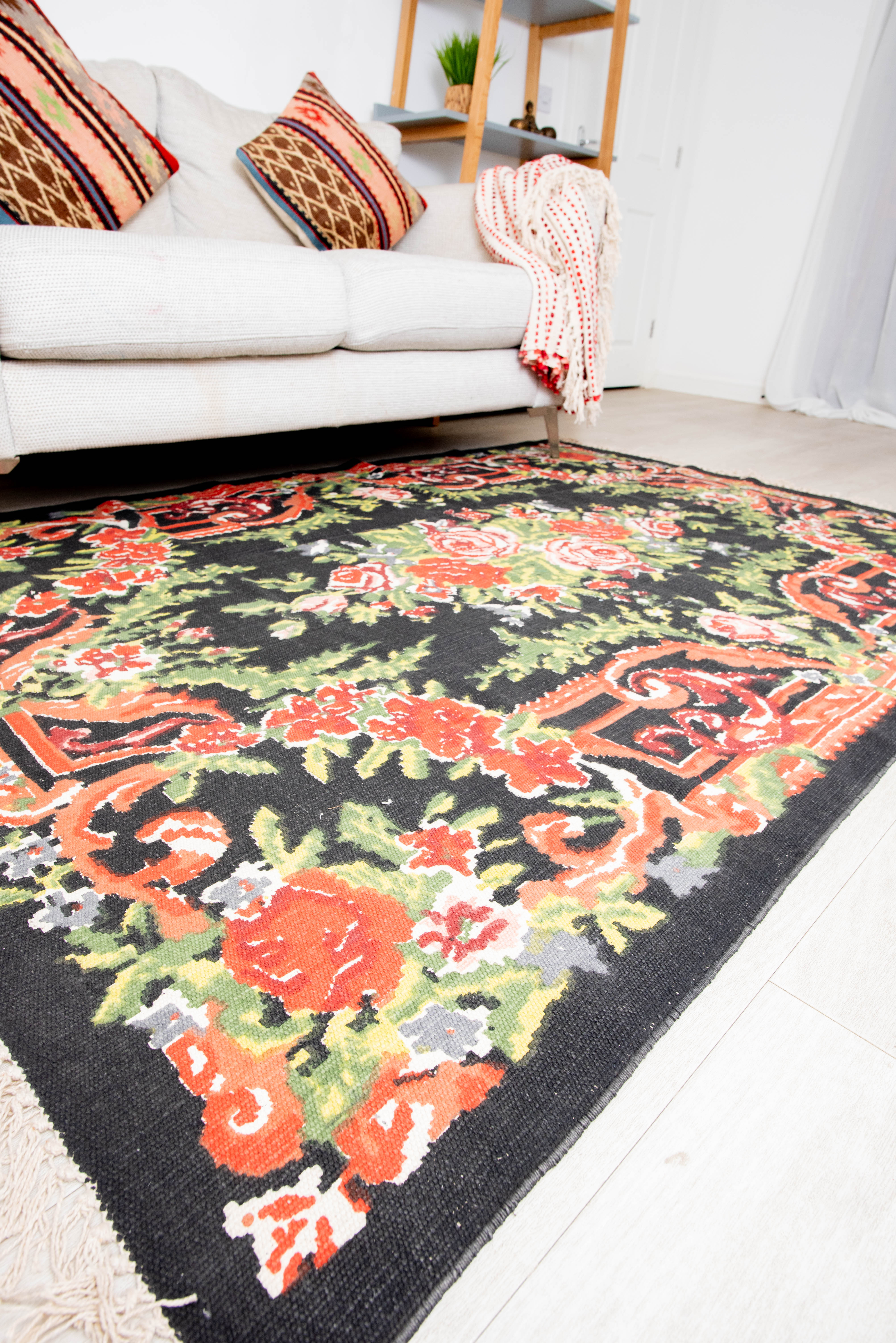 Elegant black rug with colorful flower and leaf motifs