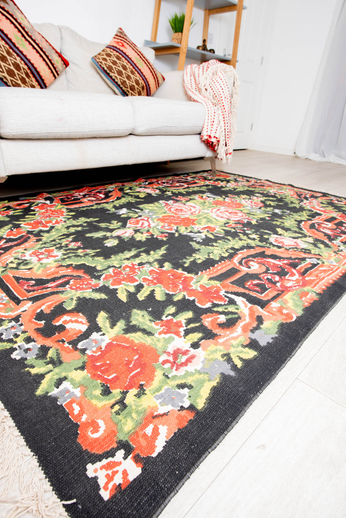 Elegant black rug with colorful flower and leaf motifs