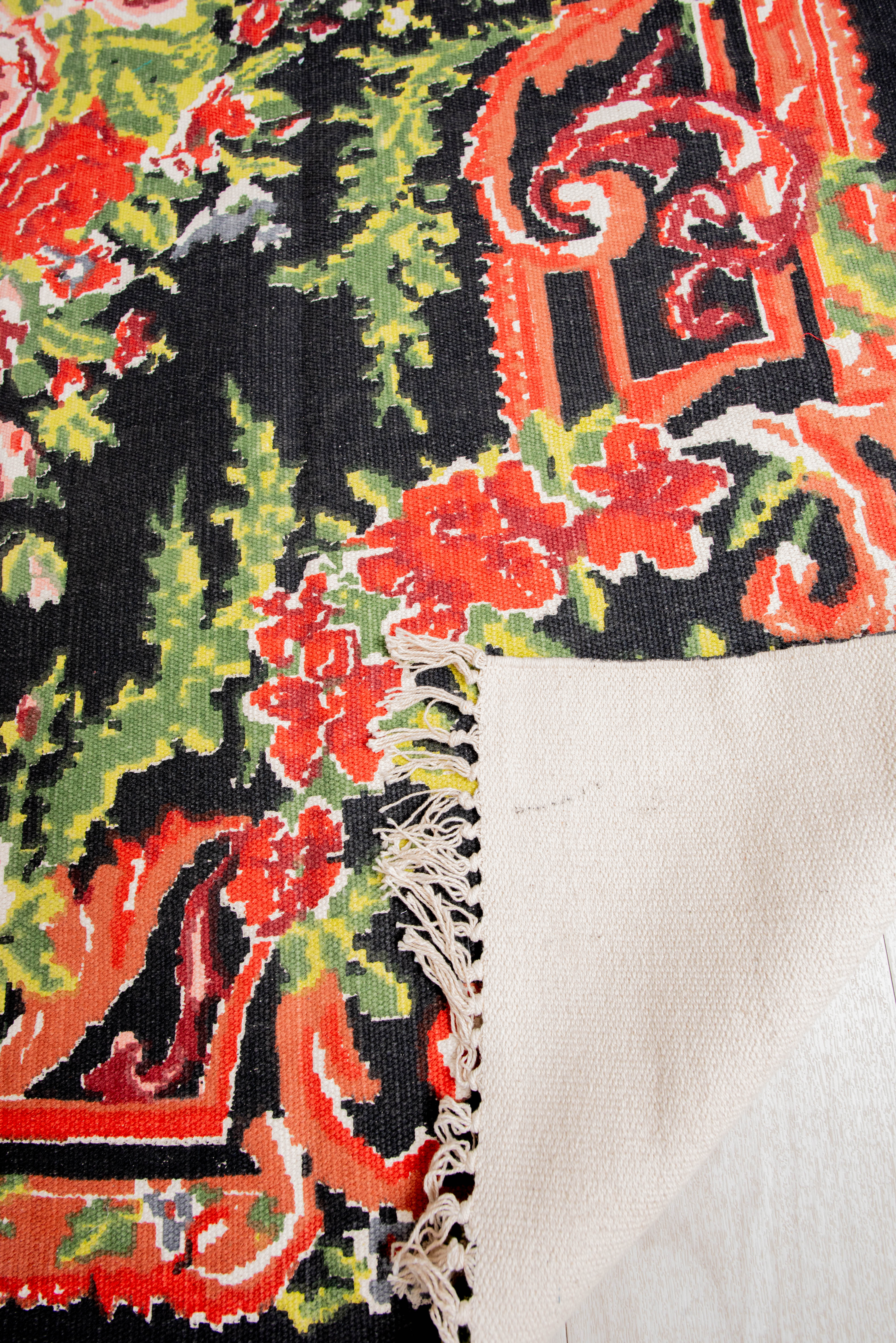 Elegant black rug with colorful flower and leaf motifs