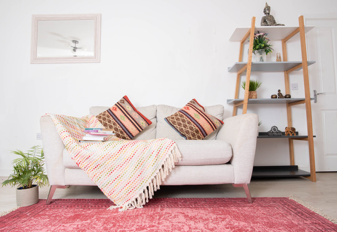 Modern beige sofa with patterned cushions and throw