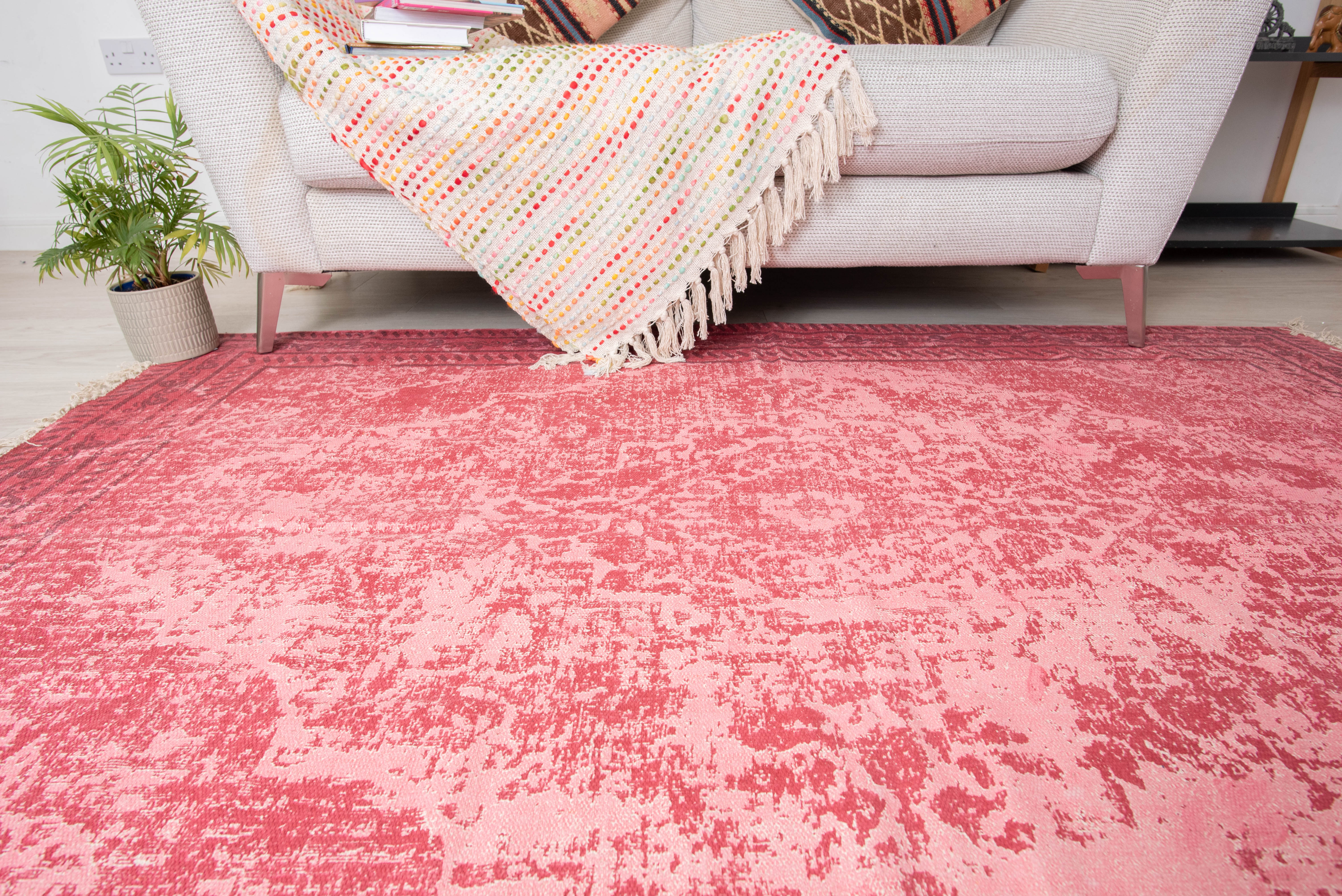 This item is a pink and white traditional printed area rug, likely matching styles from brands like Kaleen India or MUJOO, designed with a distressed vintage pattern. 