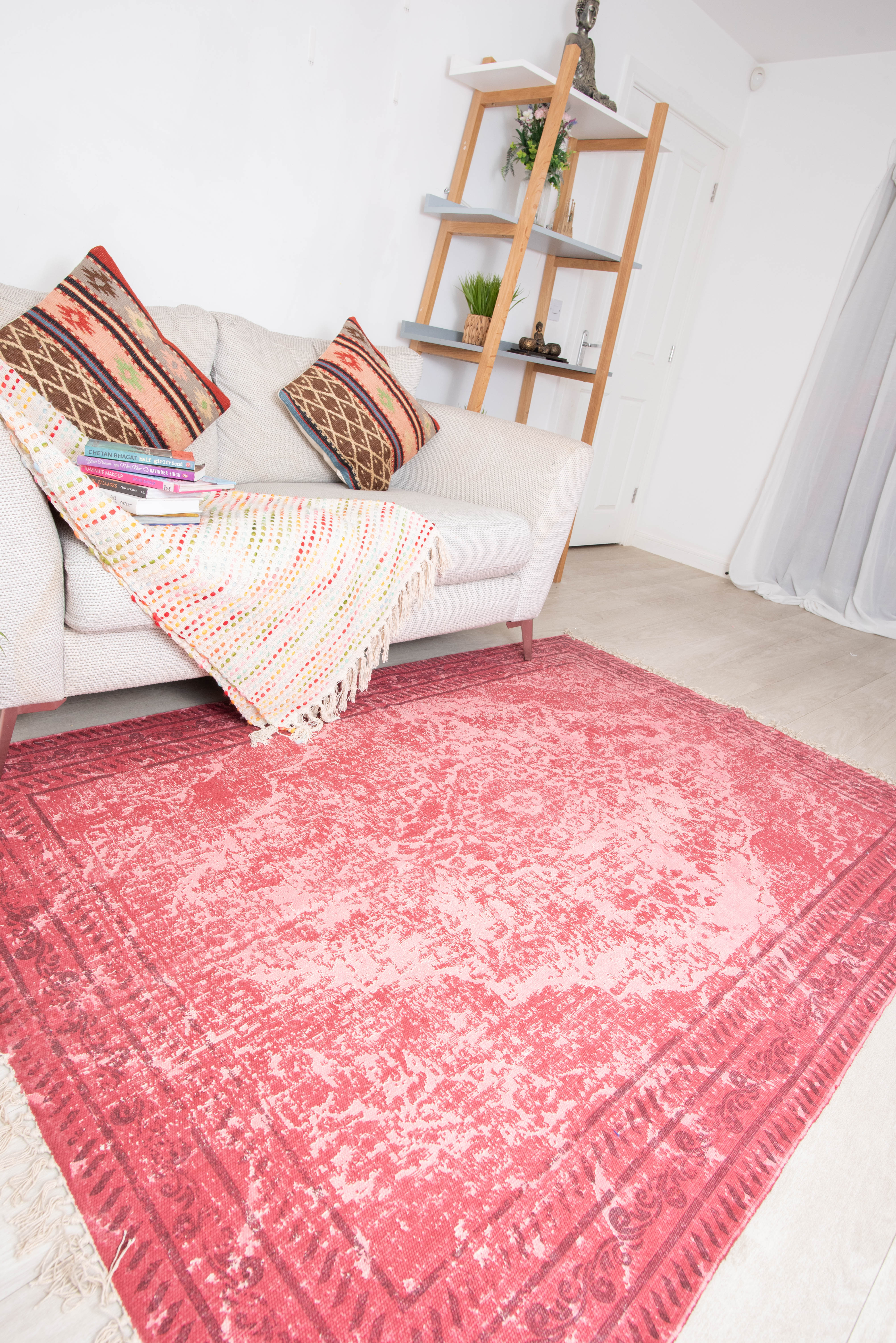 Cozy living room with pink patterned rug and beige sofa