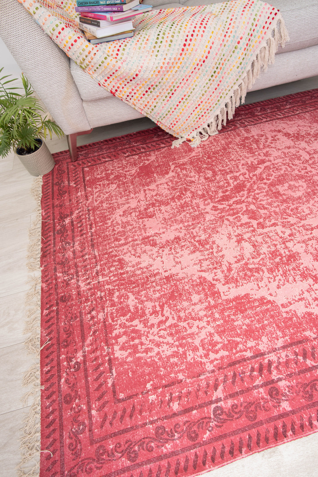 This vintage-inspired, overdyed pink area rug appears to be similar to models from brands such as Rugsmith, Mujoo, or Kaleen,