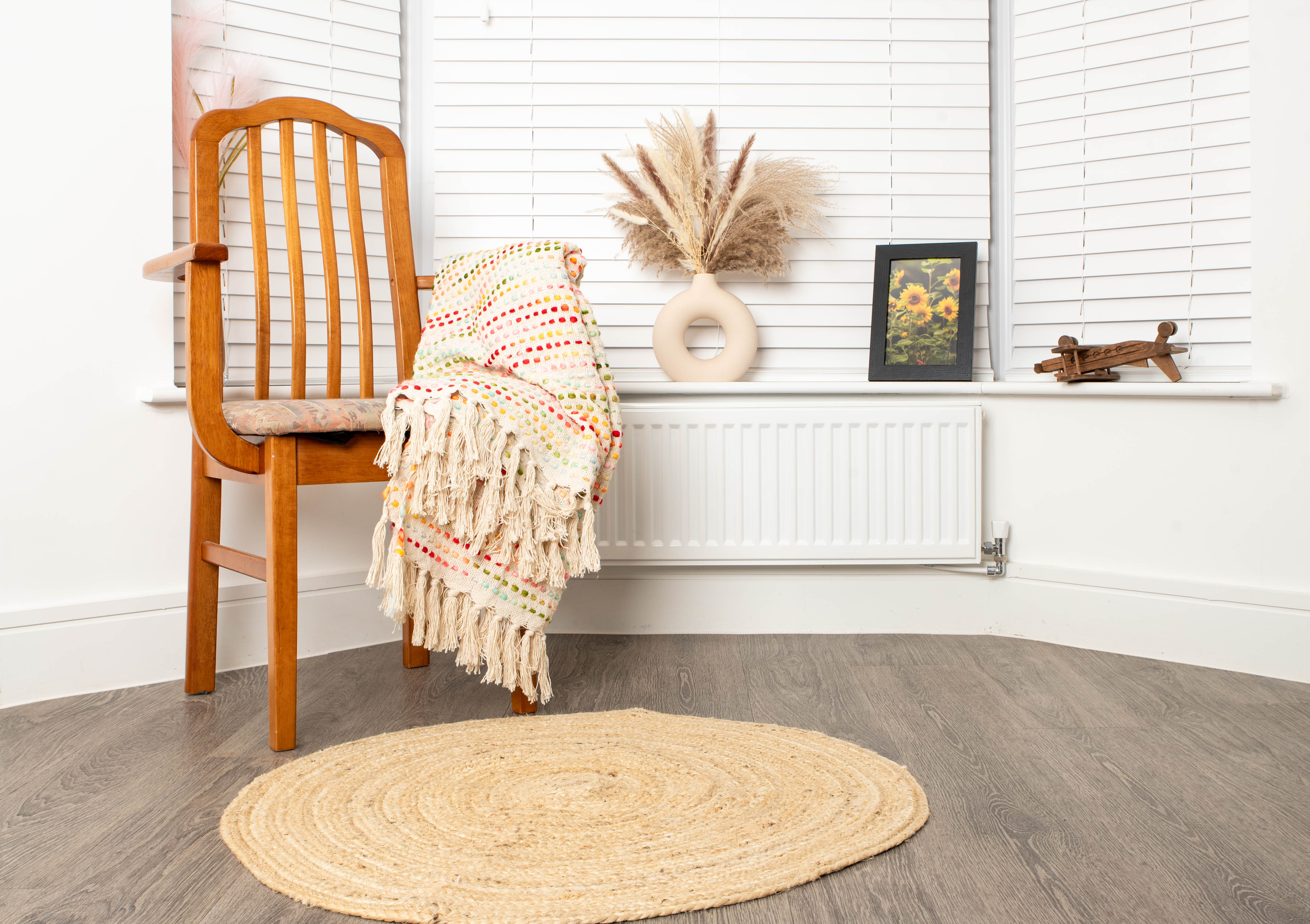 Cozy corner with chair, striped blanket, and braided rug