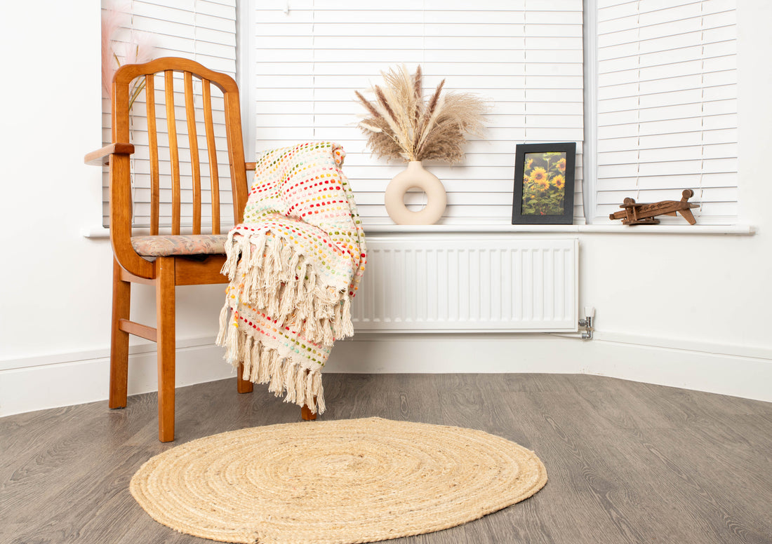 Cozy corner with chair, striped blanket, and braided rug