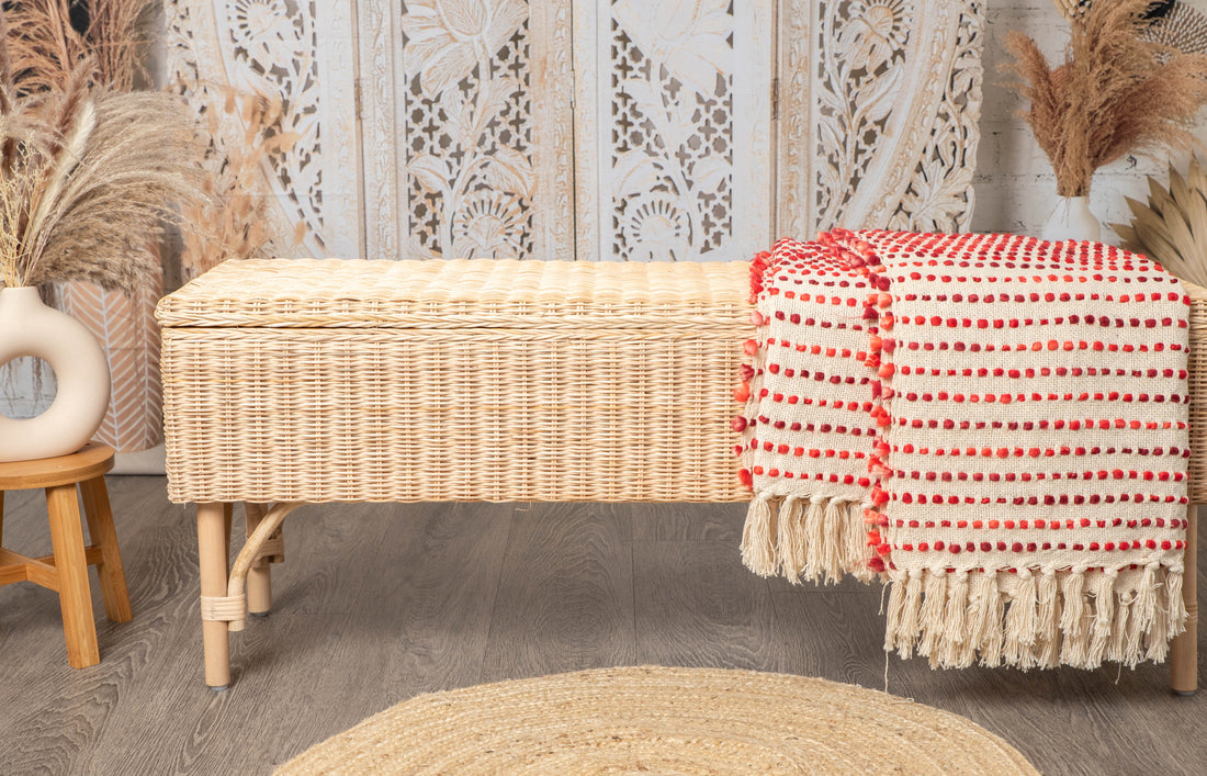 Bohemian wicker bench with cream throw and woven rug in cozy interior