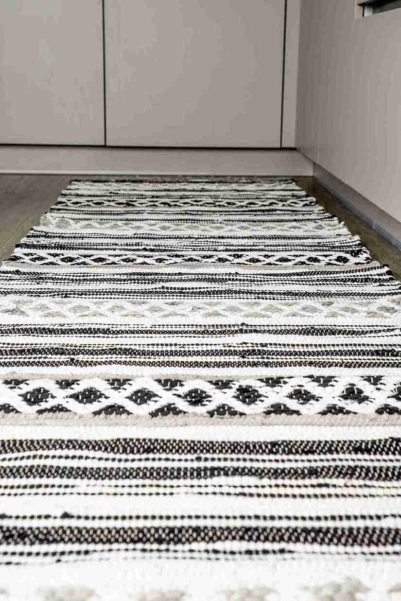 Black and white patterned rug on a wooden floor