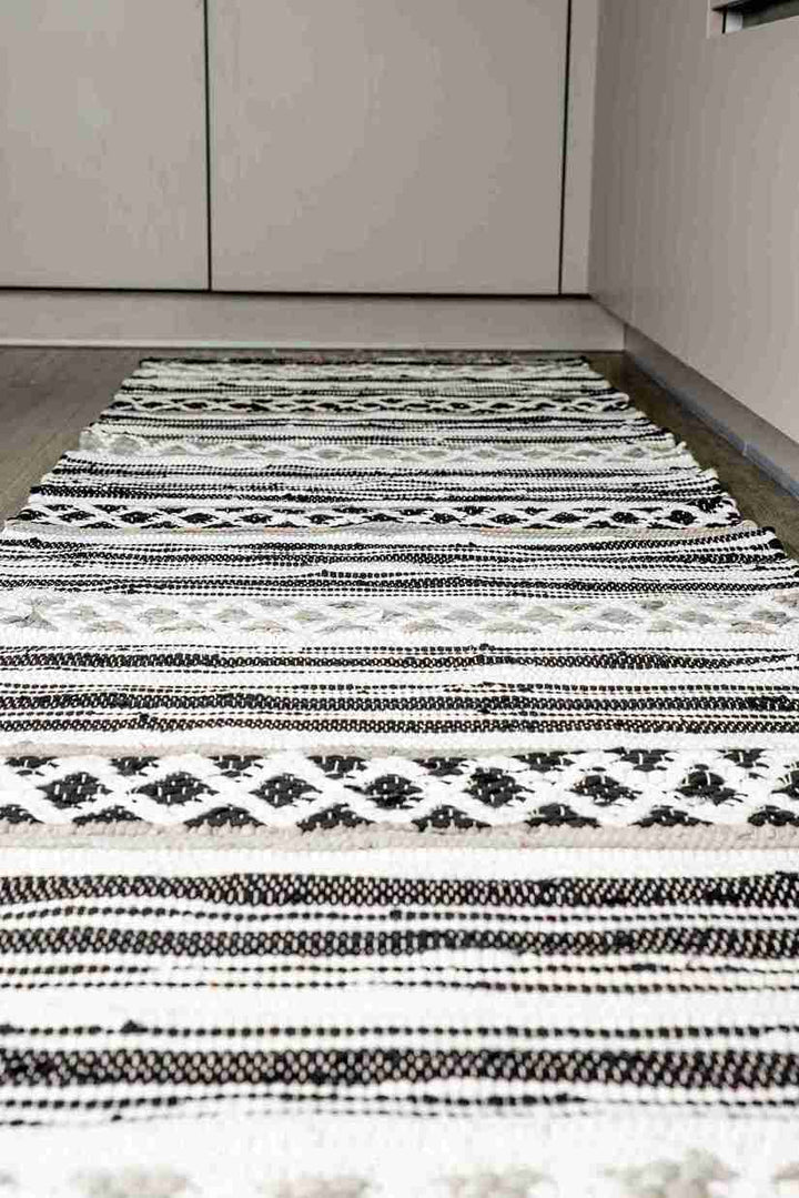 Black and white patterned rug on a wooden floor
