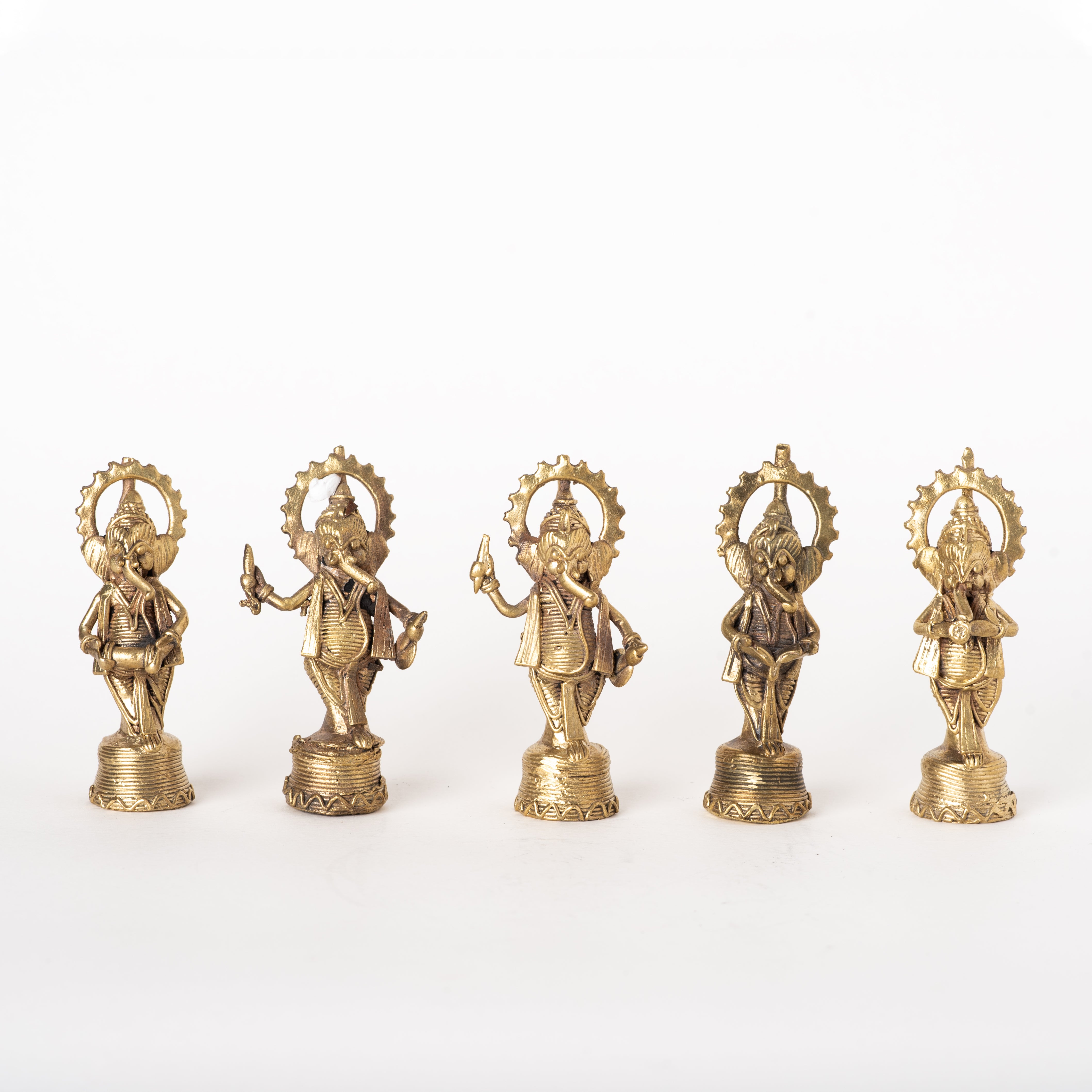 A set of five brass amulet figurines depicting the Hindu god Ganesh, each on a small base, with intricate details and designs.