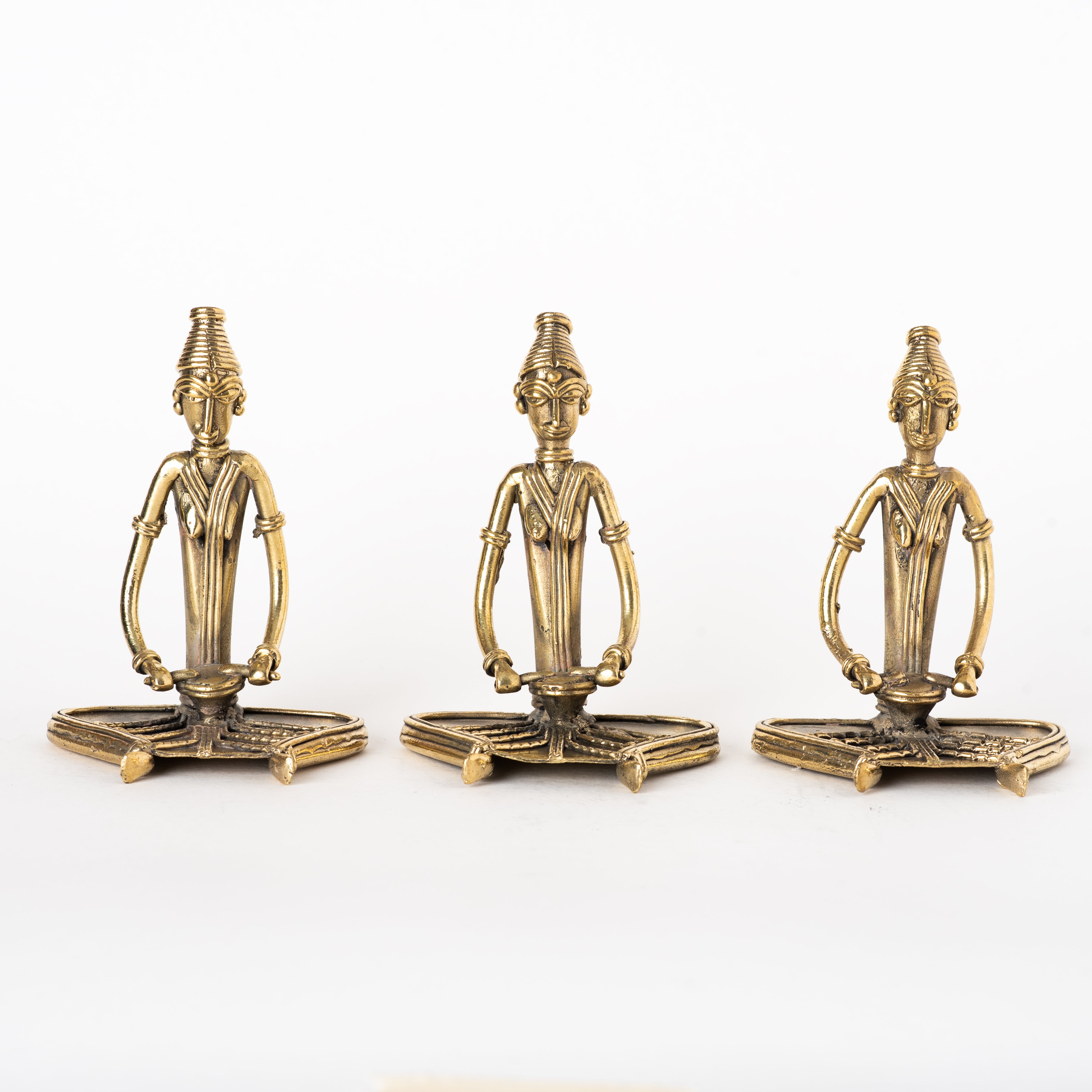 These items are handcrafted Dhokra art brass metal figurines depicting sitting women musicians playing percussion instruments. 