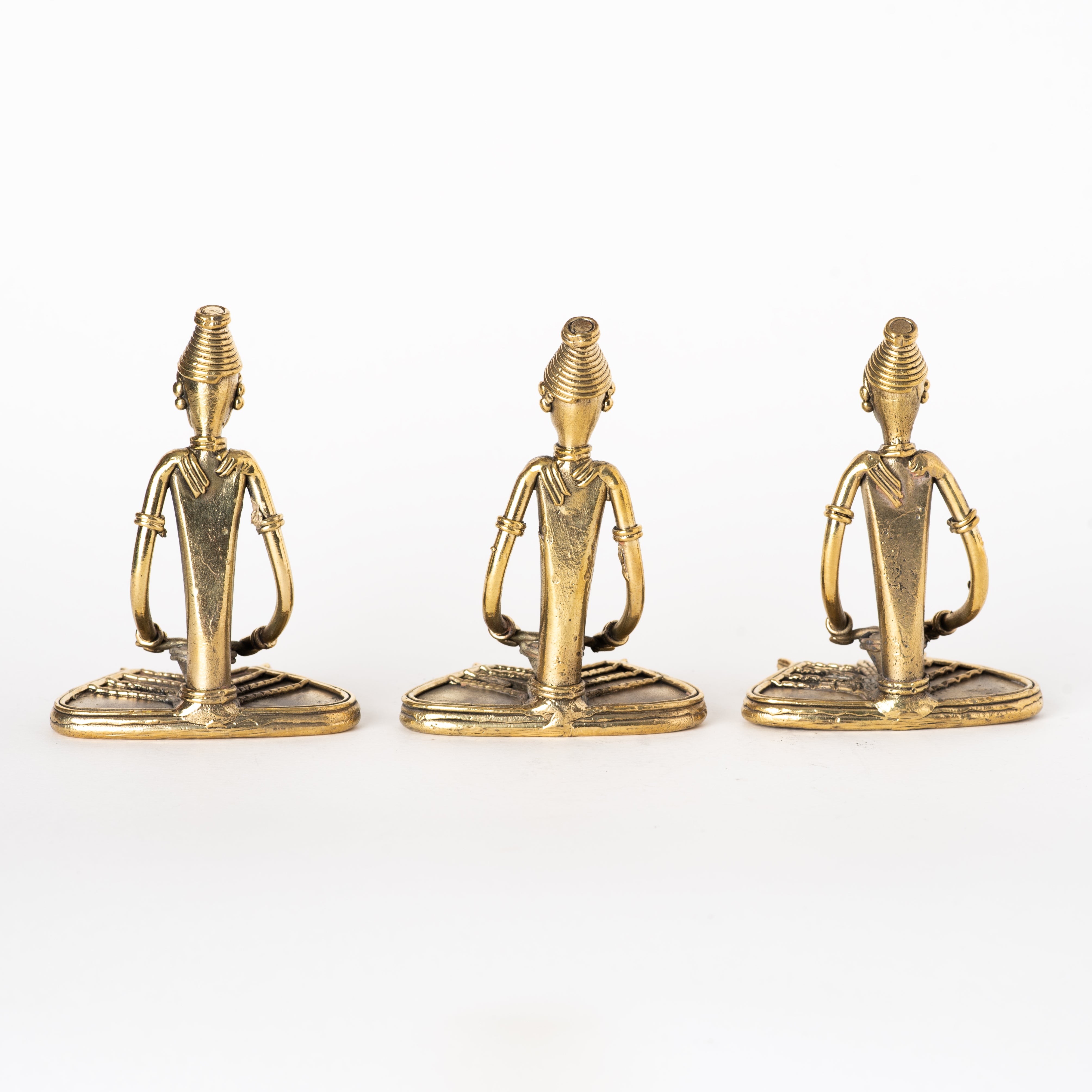 These figurines are handcrafted Dhokra art brass collectibles representing tribal musicians or ladies reading, typical of Odisha, India. 