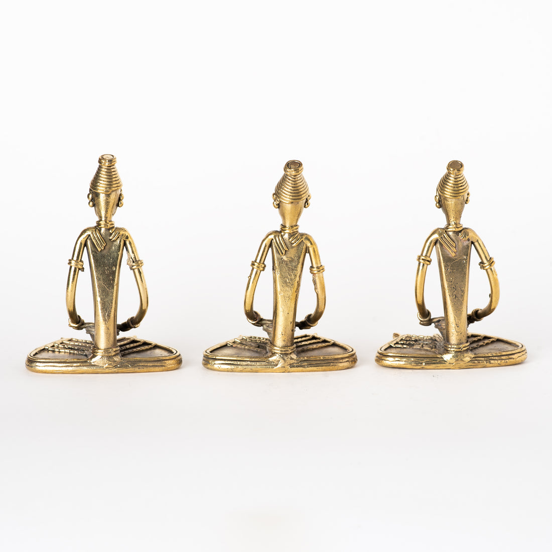 These figurines are handcrafted Dhokra art brass collectibles representing tribal musicians or ladies reading, typical of Odisha, India. 