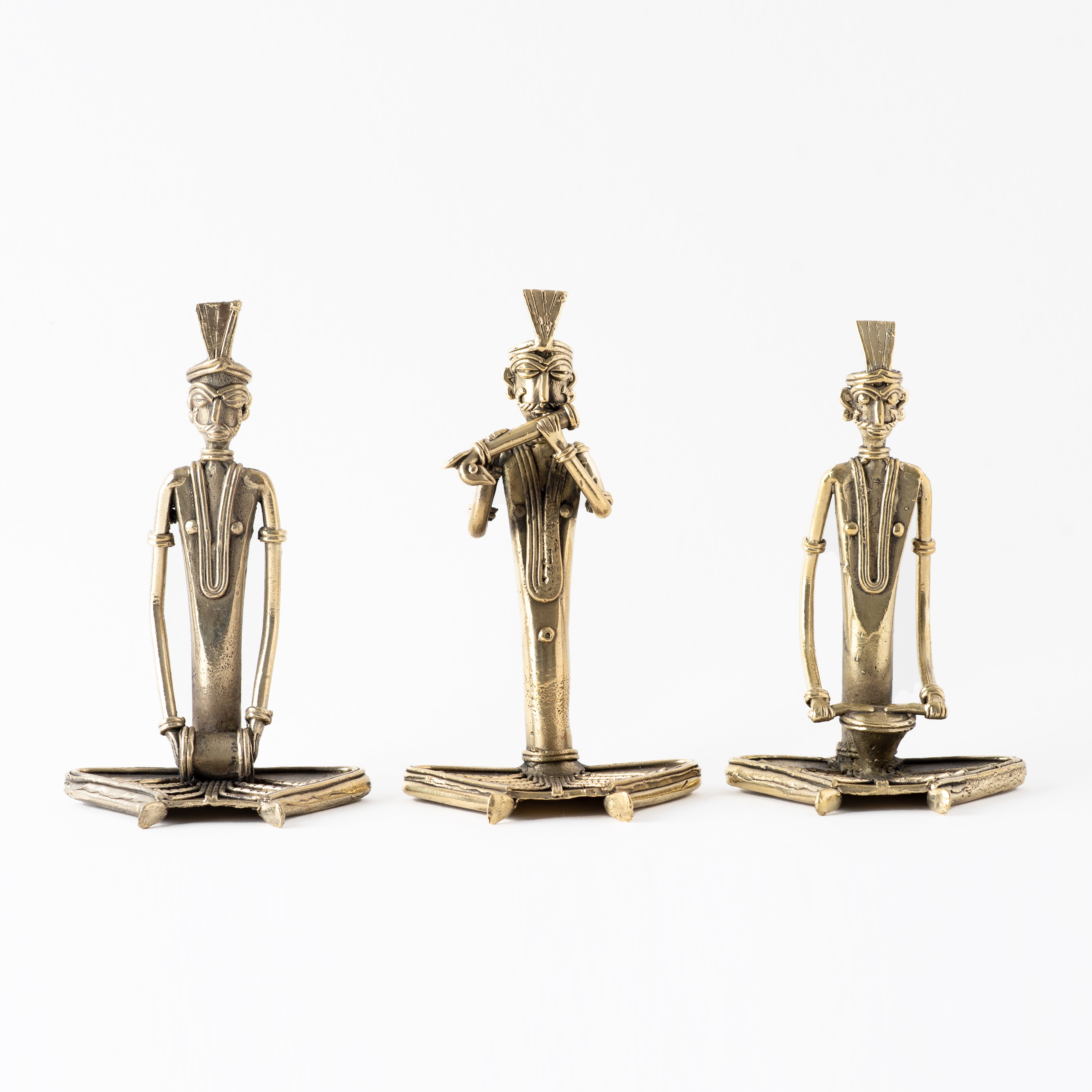 Four brass metal sculptures of sitting men musicians